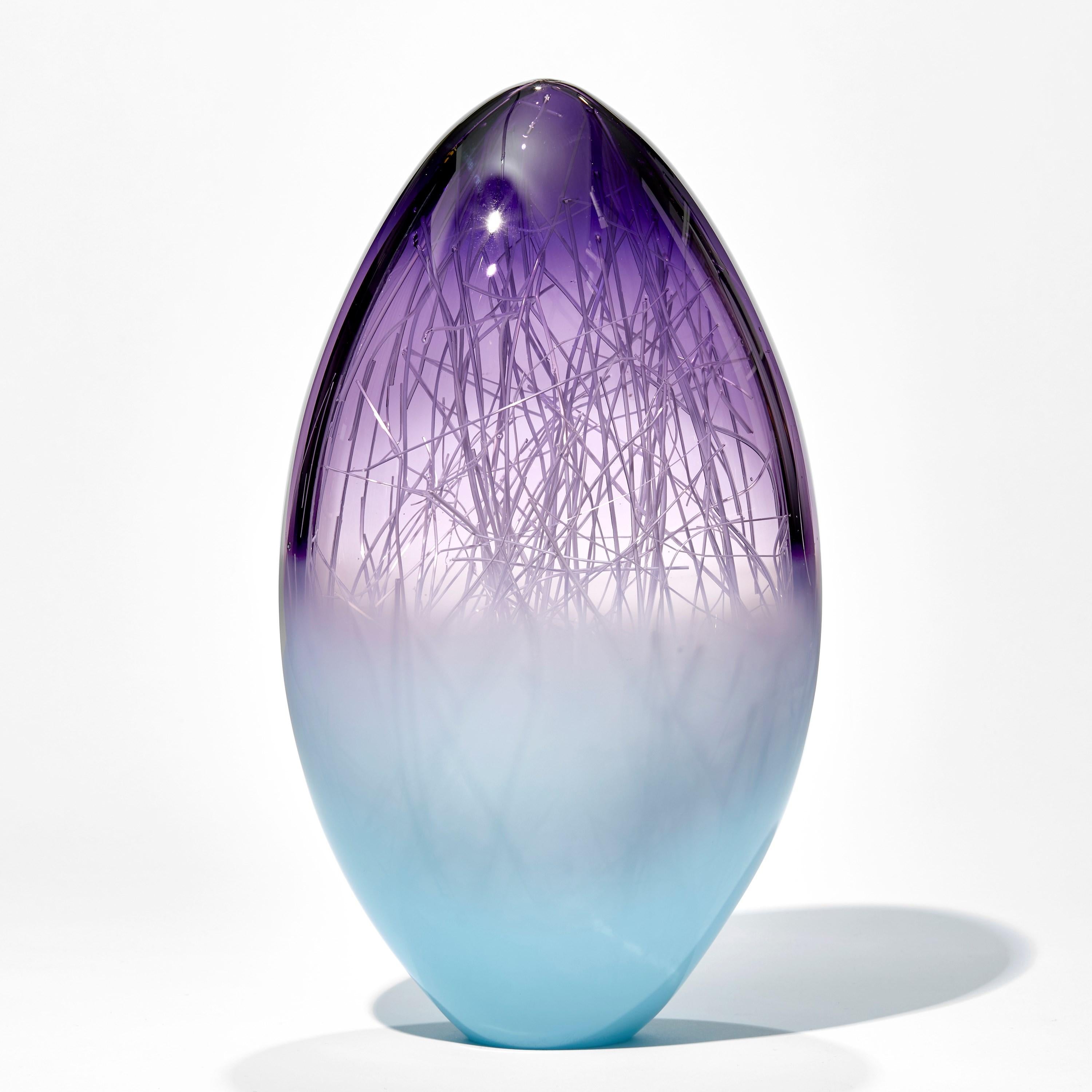 Panicum in Indigo and Pale Turquiose è una scultura unica in vetro colorato di viola e blu tenue realizzata dagli artisti Hanne Enemark (danese) e Louis Thompson (britannico). La forma di vetro esterna contiene una moltitudine di sottili canne di