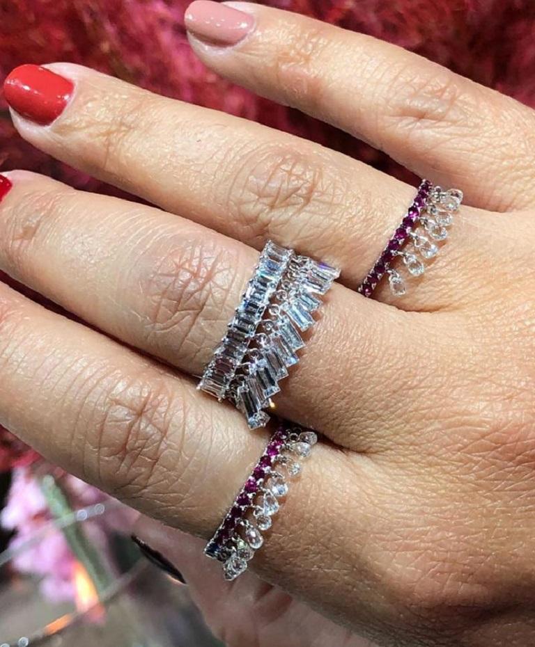 PANIM White Diamond Briolettes in Ruby Band Dangling Ring in 18K WhiteGold

Inspired by the beauty of a rain drop, Our eccentric Dangling diamond ring is an absolute show-stopper. it has 10 pieces Rain Drops White Diamond Briolettes set with Round