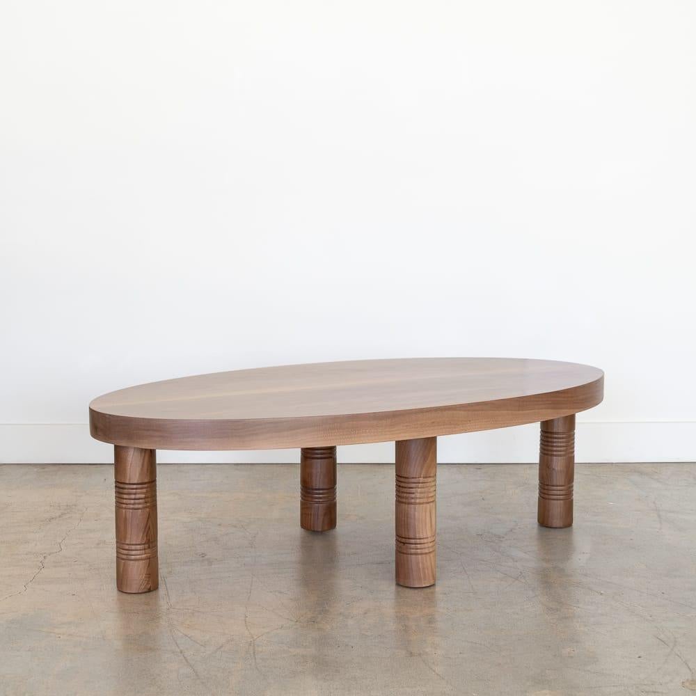 Newly made solid walnut oval coffee table with four post legs and carved ribbed detailing; inspired by French design. Beautiful oval shape with 2.25