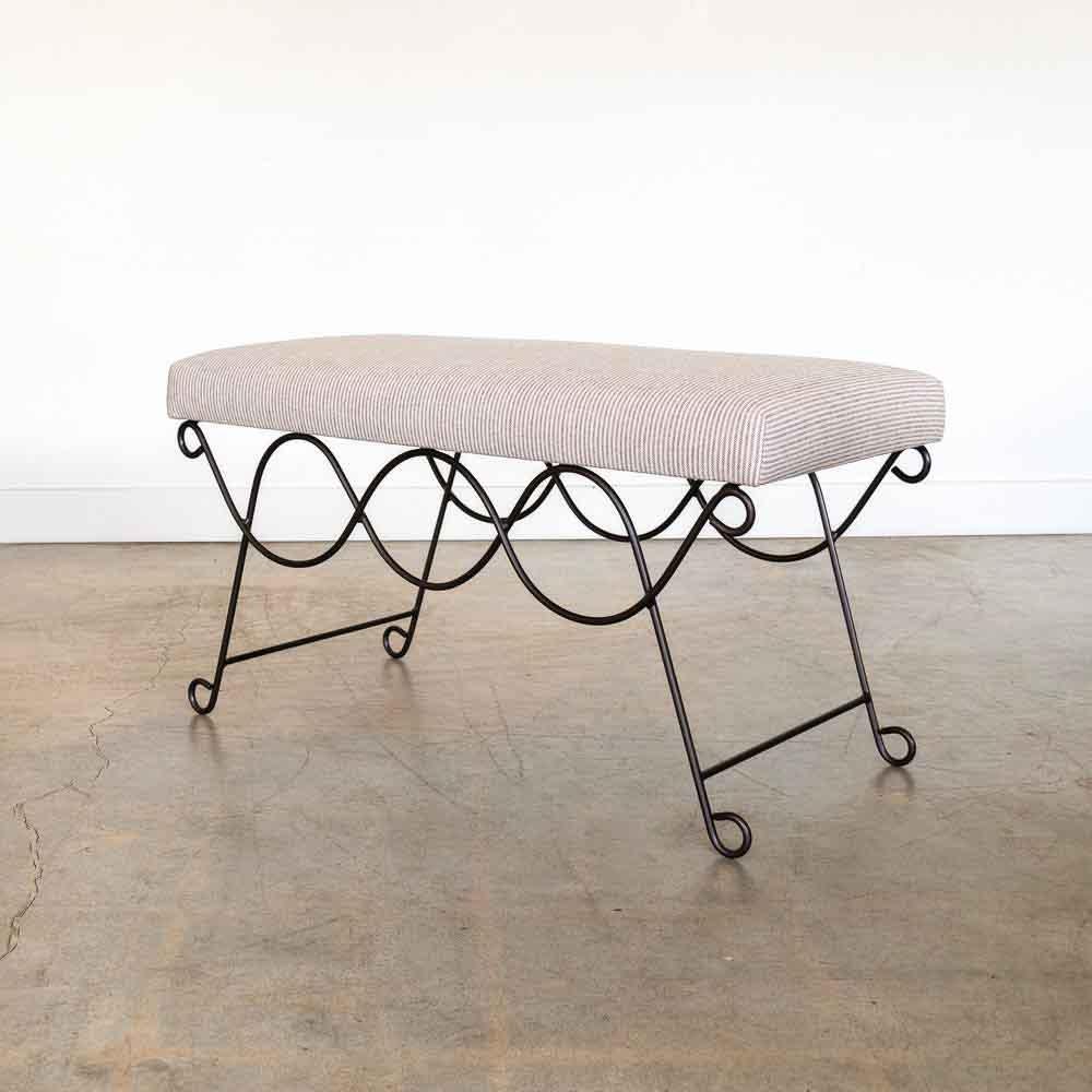 Beautiful iron bench with curved and looped base painted in a matte black finish inspired by French design. Rectangular cushioned seat upholstered in a brown stripe linen fabric or can be COM. Multiple available, sold individually. Made in Los