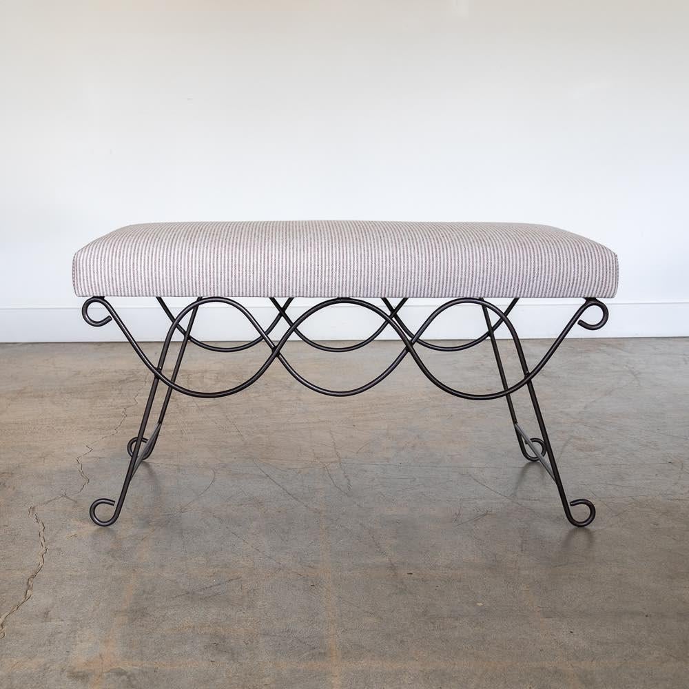 Beautiful iron bench with curved and looped base painted in a matte black finish inspired by French design. Rectangular cushioned seat upholstered in a brown stripe linen fabric or can be COM. Multiple available, sold individually. Made in Los