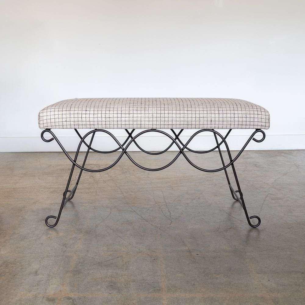 Beautiful iron bench with curved and looped base painted in a matte black finish inspired by French design. Rectangular cushioned seat upholstered in a linen check fabric or can be COM. Multiple available, sold individually. Made in Los Angeles. 