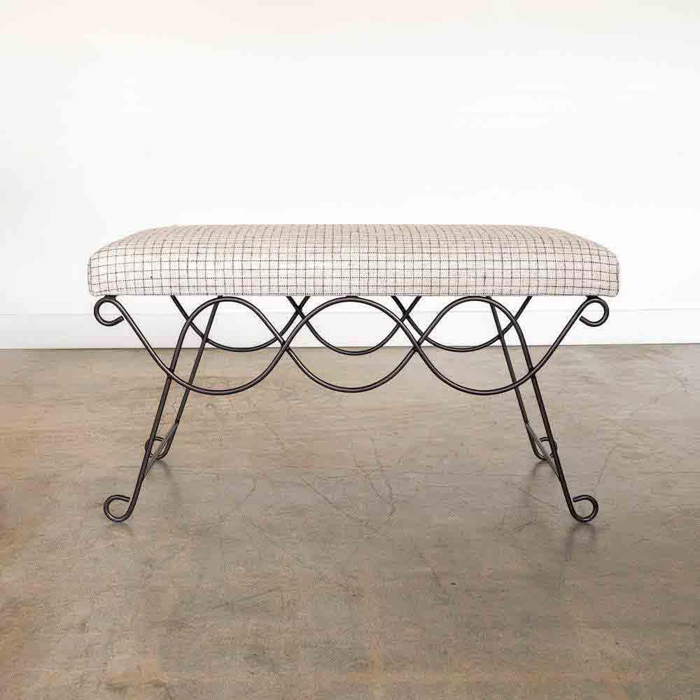 Beautiful iron bench with curved and looped base painted in a matte black finish inspired by French design. Rectangular cushioned seat upholstered in a linen check fabric or can be COM. Multiple available, sold individually. Made in Los Angeles. 
