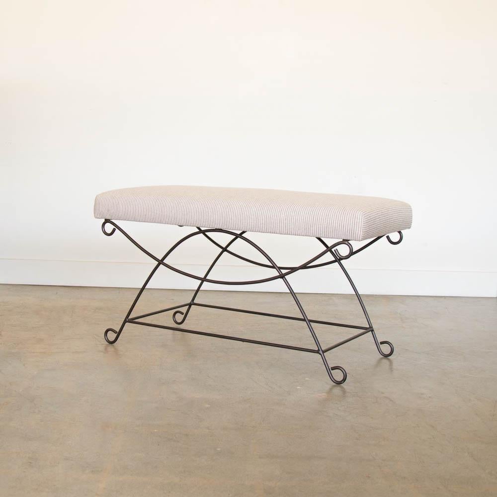 Beautiful iron bench with curved and looped base painted in a matte black finish inspired by French design. Rectangular cushioned seat upholstered in a brown stripe fabric or can be COM. Multiple available, sold individually. Made in Los Angeles.