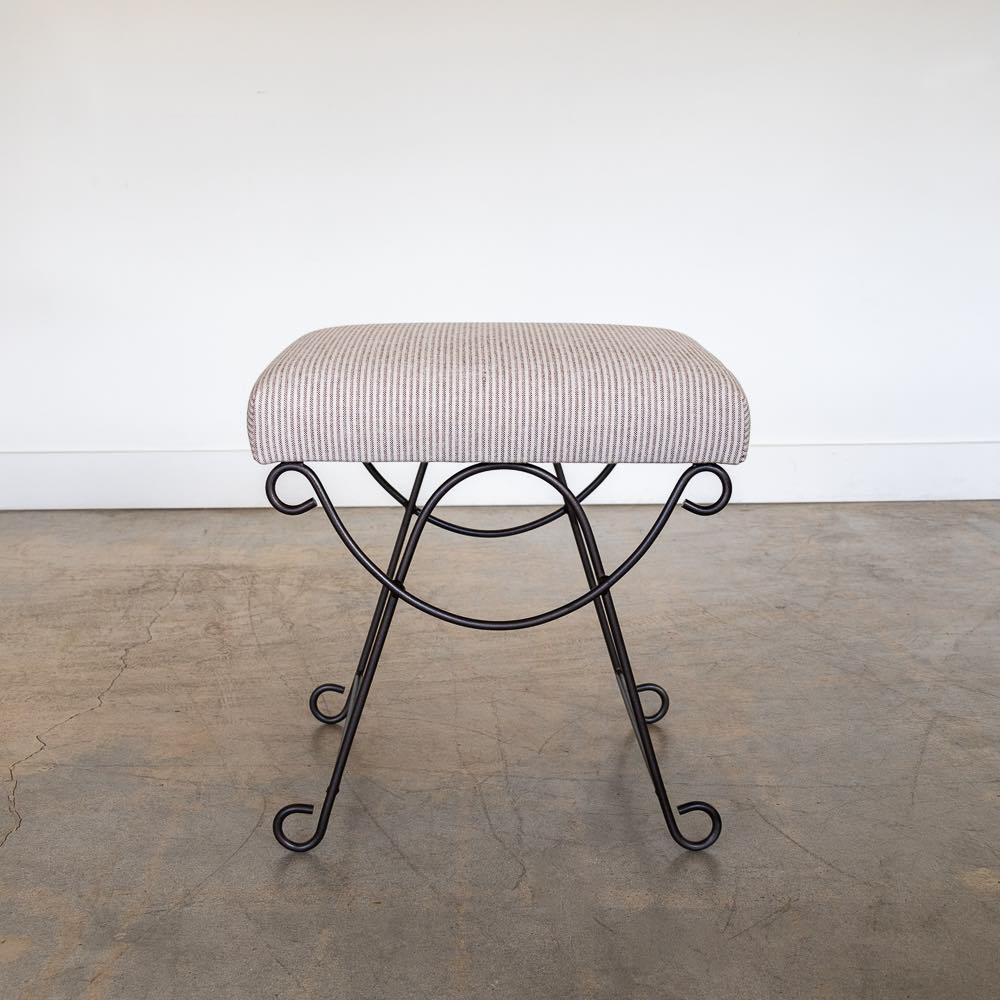 Beautiful iron stool with curved and looped base painted in a matte black finish inspired by French design. Rectangular cushioned seat upholstered in a brown stripe linen or can be COM. Made in Los Angeles. 