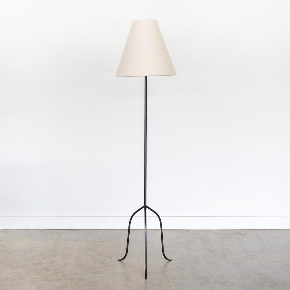 Iron tripod floor lamp with slender legs and tapered feet. New wiring and new linen shade. Sold individually and newly made by Panoplie. Please inquire for current lead time. Measures 63.5 