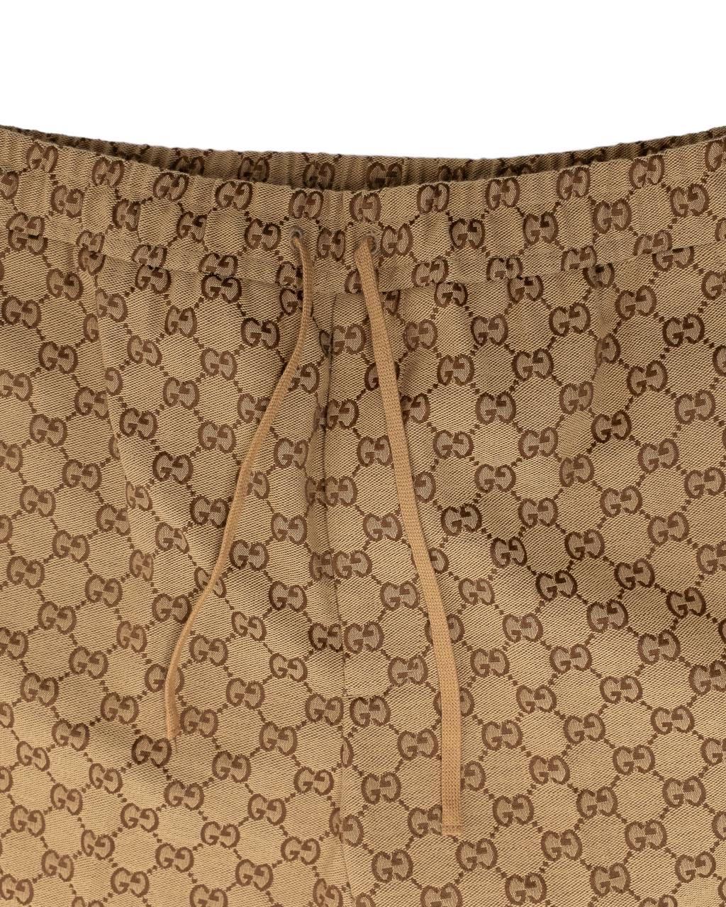 Pantalone firmato Gucci, realizzato in cotone e poliestere colore beige nella classica fantasia GG Supreme. Dotato di chiusura con laccio. Presenta tasche sia anteriori che posteriori. Taglia 44 EU. Si presenta in ottime condizioni.

Pantaloni di