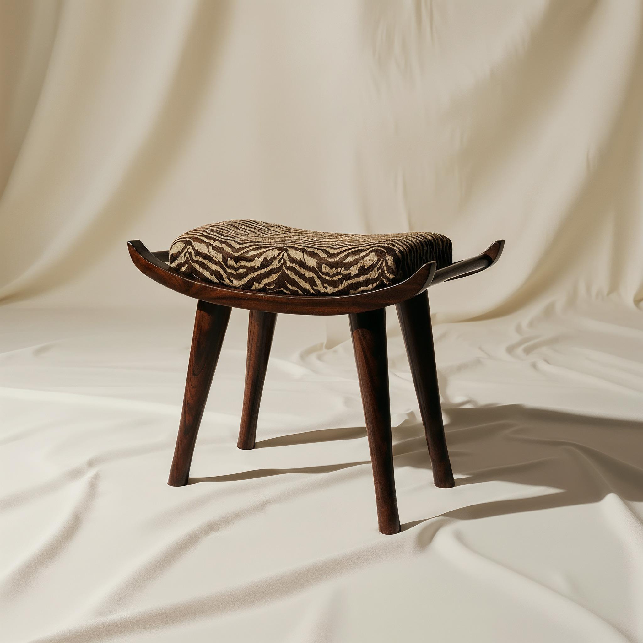 Pantera ist ein Hocker, der seine Eleganz mit ruhigem Selbstbewusstsein trägt. Das Design mit langgestreckten Linien und weicher Geometrie verbindet Komfort mit skulpturaler Klarheit. Der lackierte Holzsockel bietet eine raffinierte architektonische