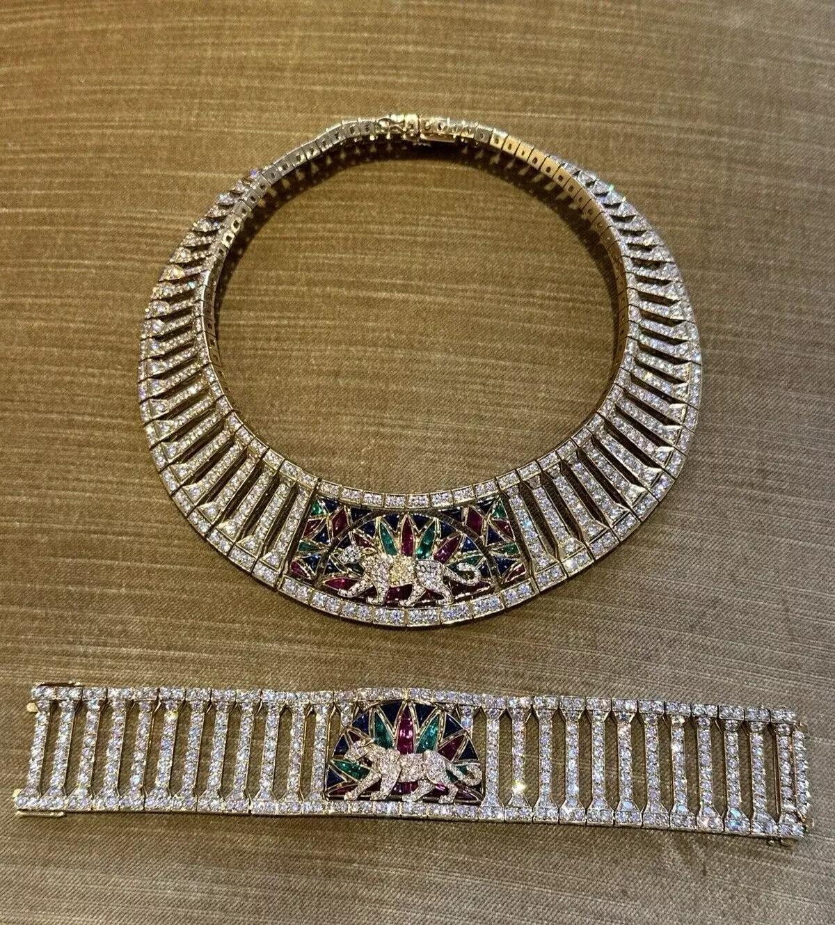 Colored Stone & Diamond Panther Necklace & Bracelet Set in 18k Yellow Gold

Columnar motif Panther Necklace and Bracelet Set centering a panther set with round diamonds, against backdrop of calibre cut rubies, emeralds and sapphires on Round