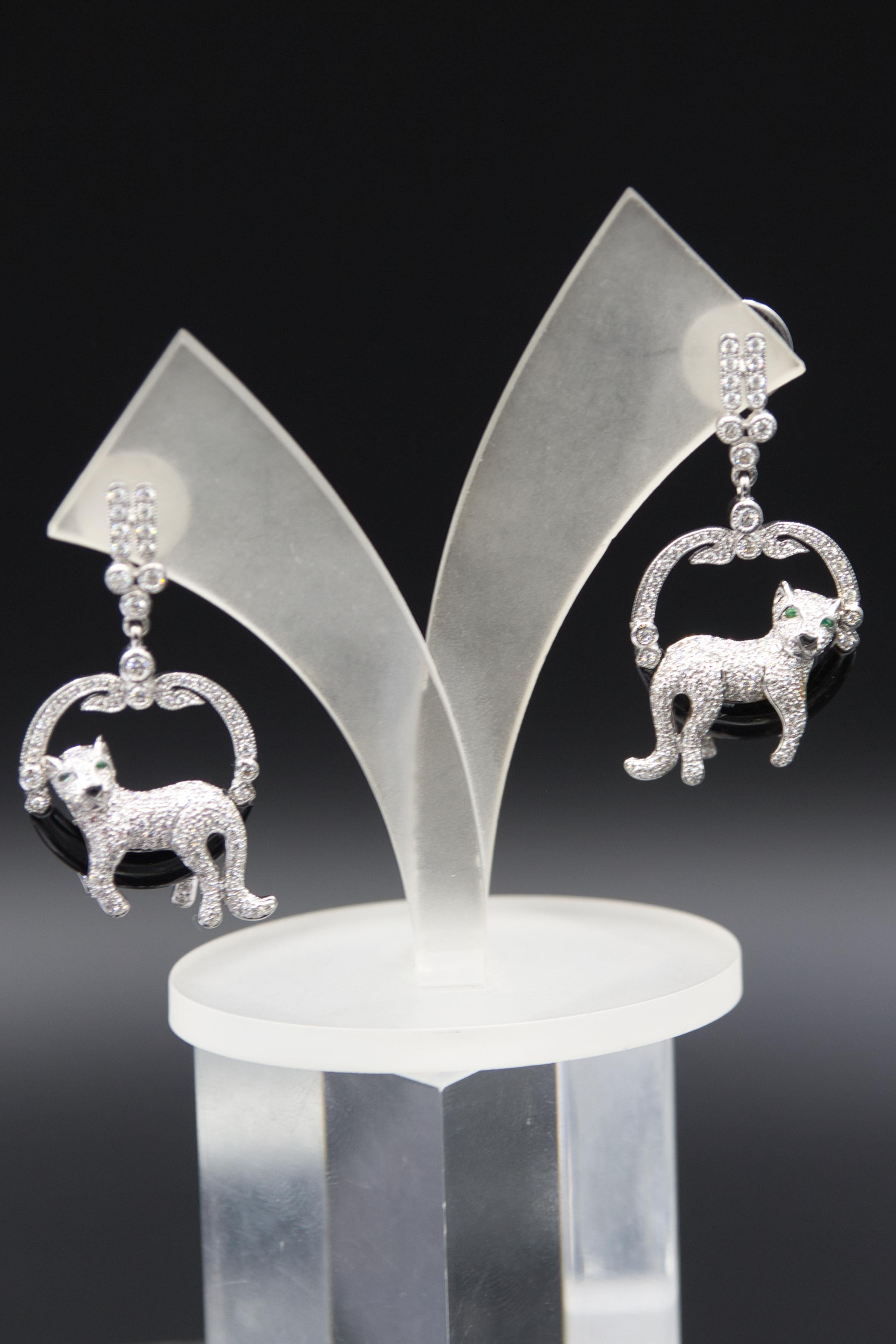 18 k white gold
1,62 ct diamant
0,18 ct emerald
14,2 gram
ca. 4 cm long


These elegant earrings are crafted from 18-karat white gold and feature an artistic panther design. They are set with a total of 1.62 carats of diamonds, which cover the