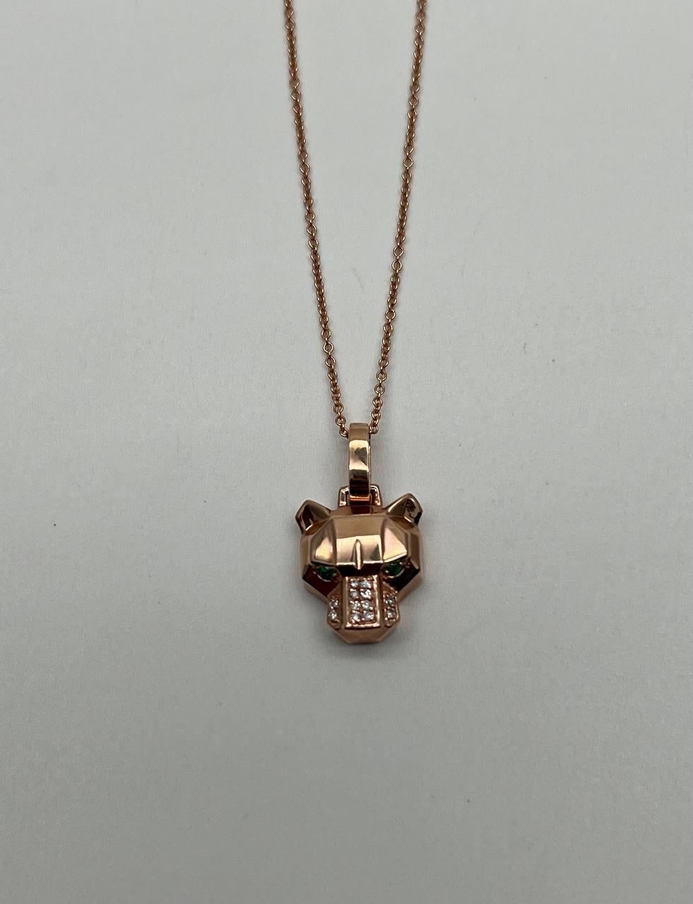 Ce collier remarquable est réalisé avec un motif géométrique de tête de lion panthère léopard. Le pendentif comporte des yeux en pierre verte émeraude et un nez orné de diamants étincelants. La pièce est suspendue à une chaîne délicate, mettant en