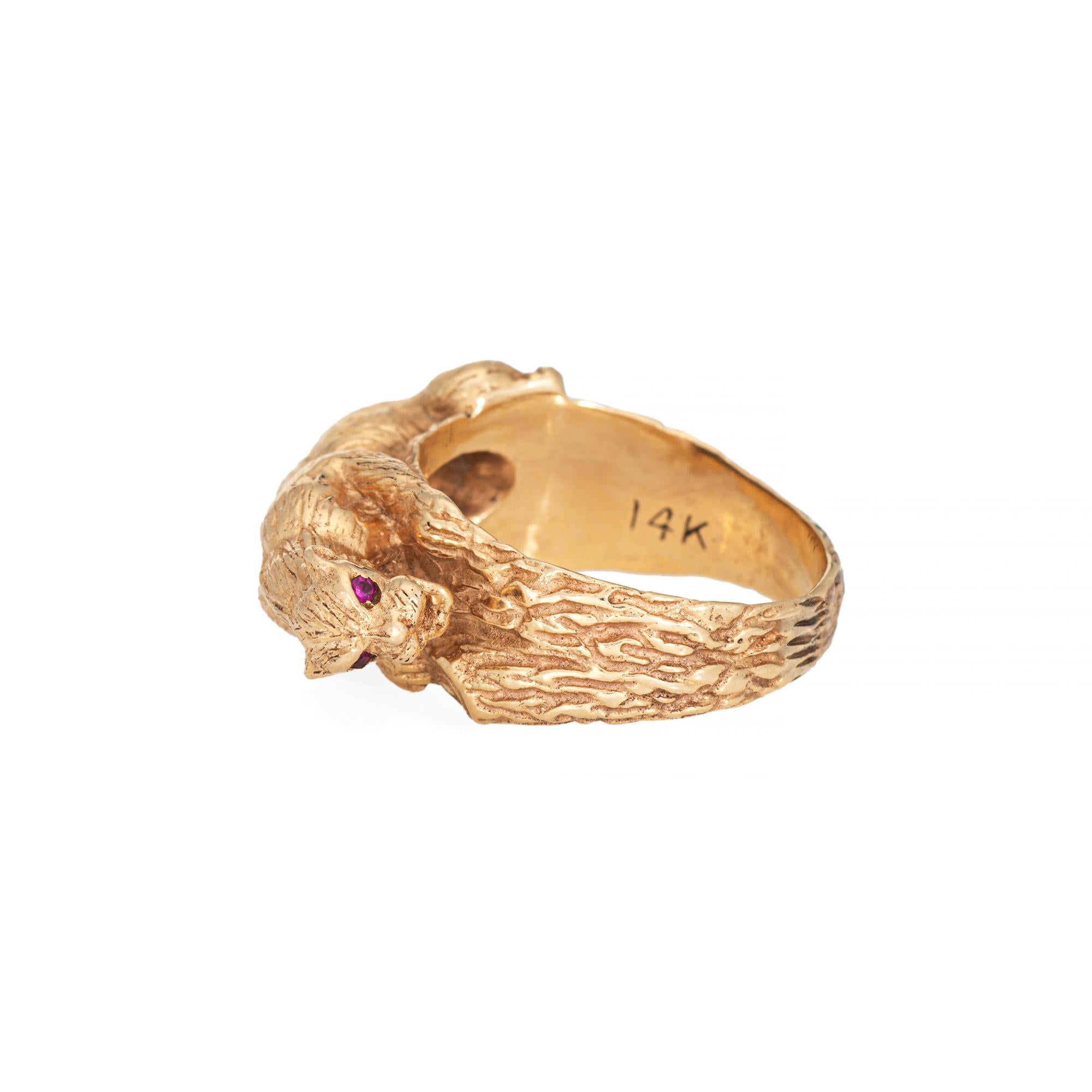 Finely detailed vintage Panther ring crafted in 14k yellow gold (circa 1960s to 1970s).  

Two red stones are set into the eyes (approx. 1.5mm each). 

The panther is artfully sculpted to hug the finger, its body curving in a perched position as if