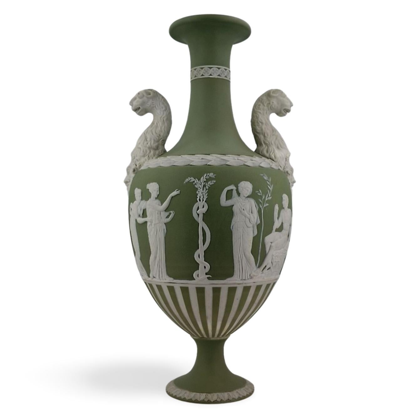 An unsually tall vase in sage green jasper, decorated with Hercules in the Garden of Hesperides, one of the Labours of Hercules. Engine-turned strips to the underside, and beautifully modelled panther heads for handles.

In Greek mythology, the