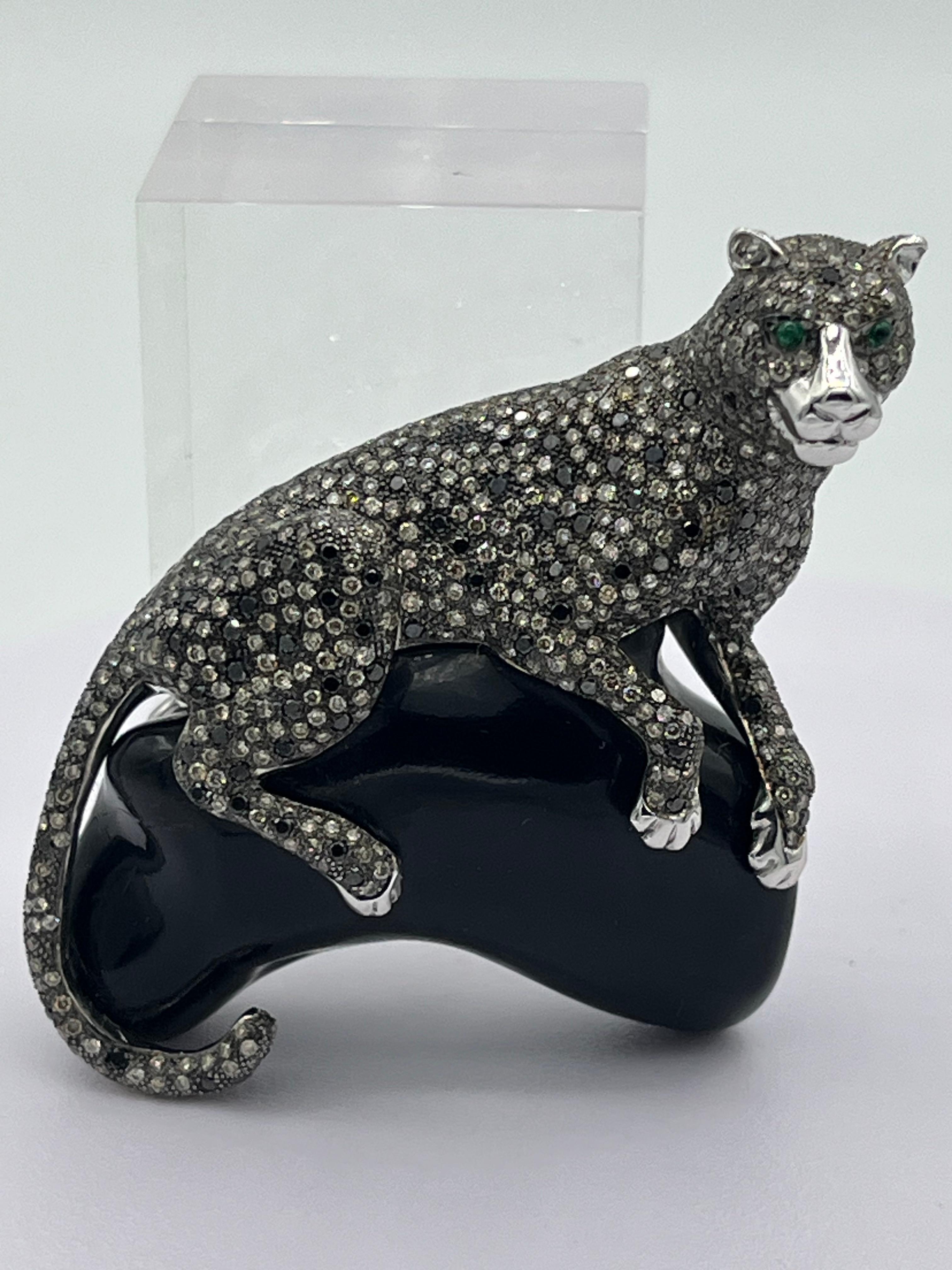 This brooch are beautiful the panther is sitting on a black stone, the panther is set with 5,53 ct brown and 1,15 ct black diamonds . the eyes are 0,05 ct emerald
the size is ca. 6 x 5,5 cm
weight is 54,4 grams
hallmarked 750 
it is white gold