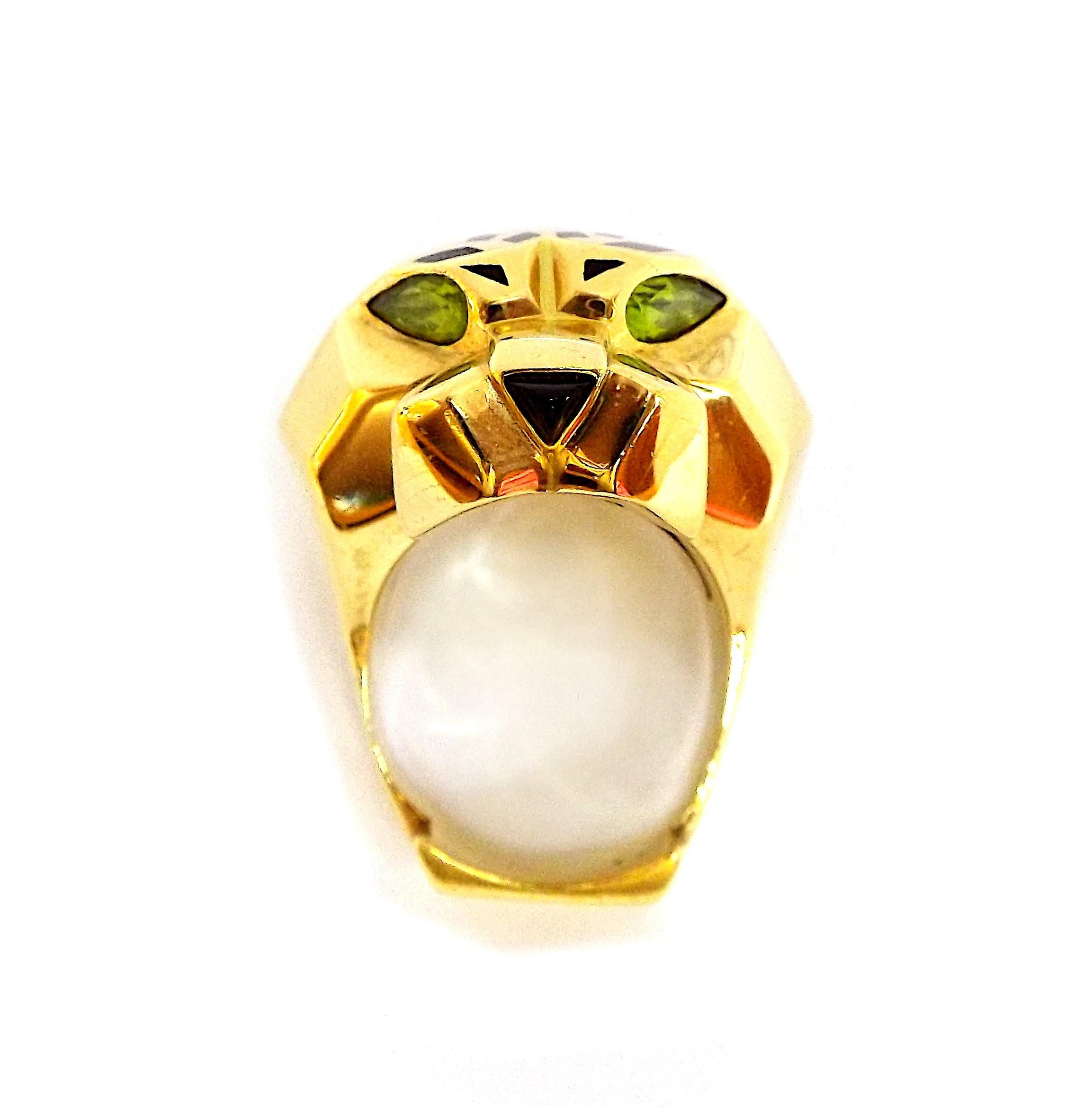 Une élégante bague en or conçue comme une tête de panthère de la collection Panthere de Cartier. Or jaune 18 carats et laque noire, péridots, onyx, EU SZ 60. Taille 9. Signé Cartier, marqué 60, numéroté.