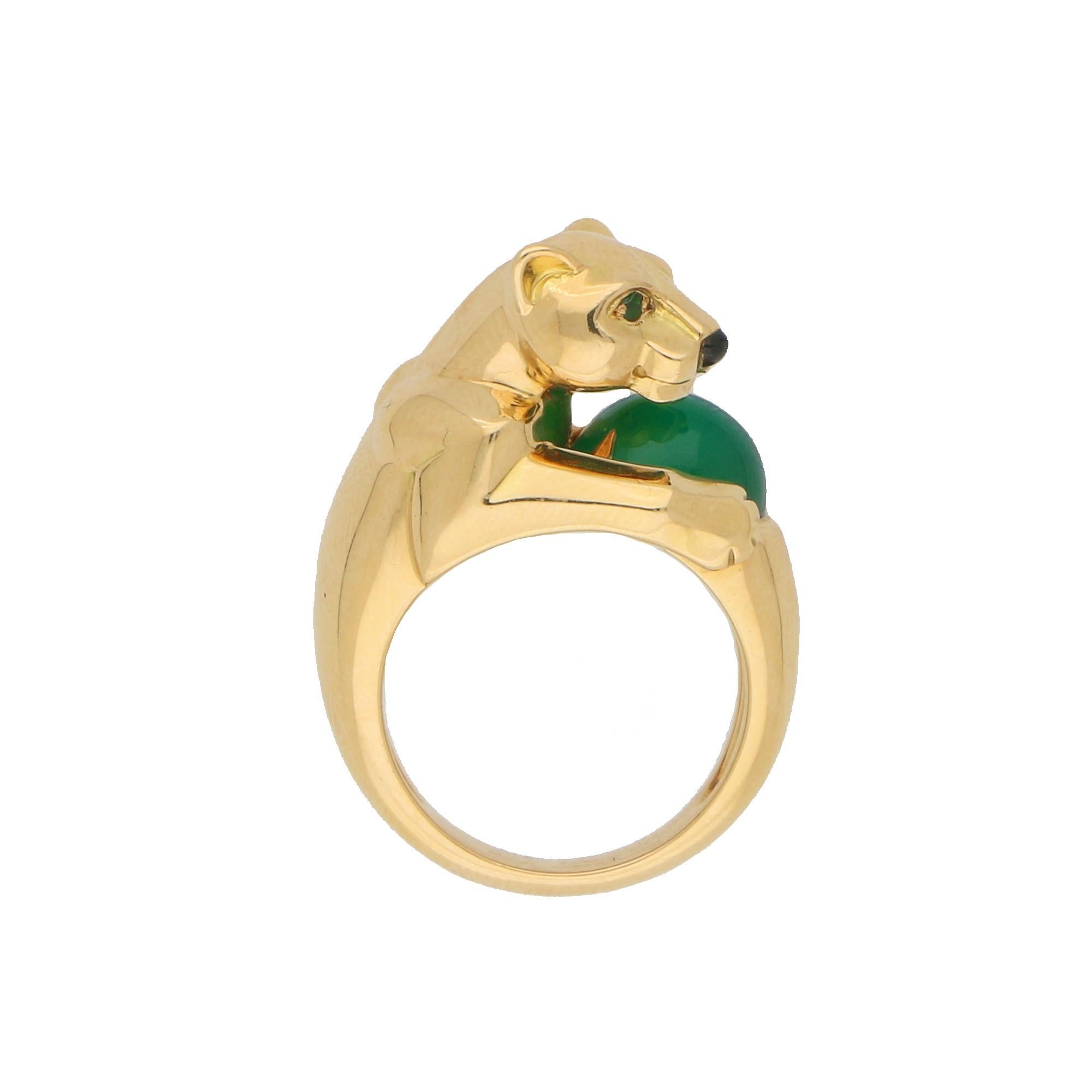 A classic Cartier Panthère ring set in solid 18k yellow gold. This rare version of the Cartier Panthère ring prominently features a polished yellow gold panther motif holding a beautiful polished green cabochon chalcedony bead. The panther is set
