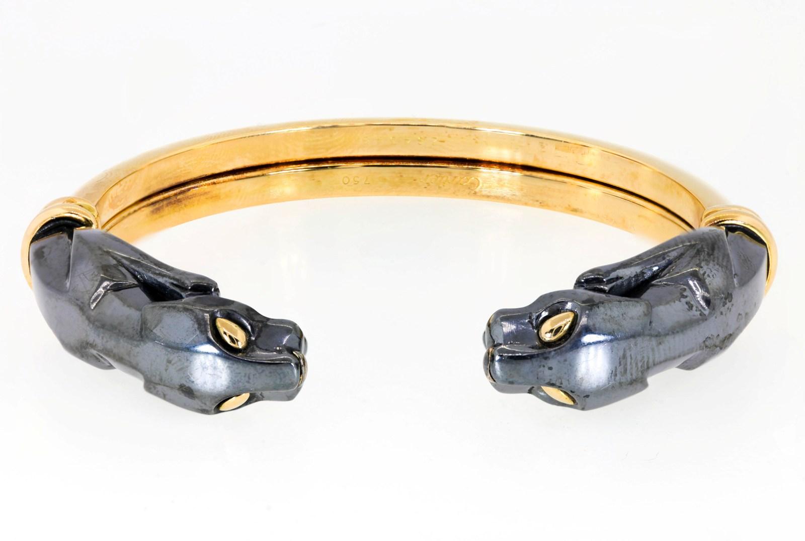 Cartier exquisitely crafted this scarce bangle in 18KT yellow gold and Hematite.  It features the iconic Cartier pouncing Panthers replete with golden eyes.  The gold section of the bangle flexes allowing easy wear and removal on a medium size