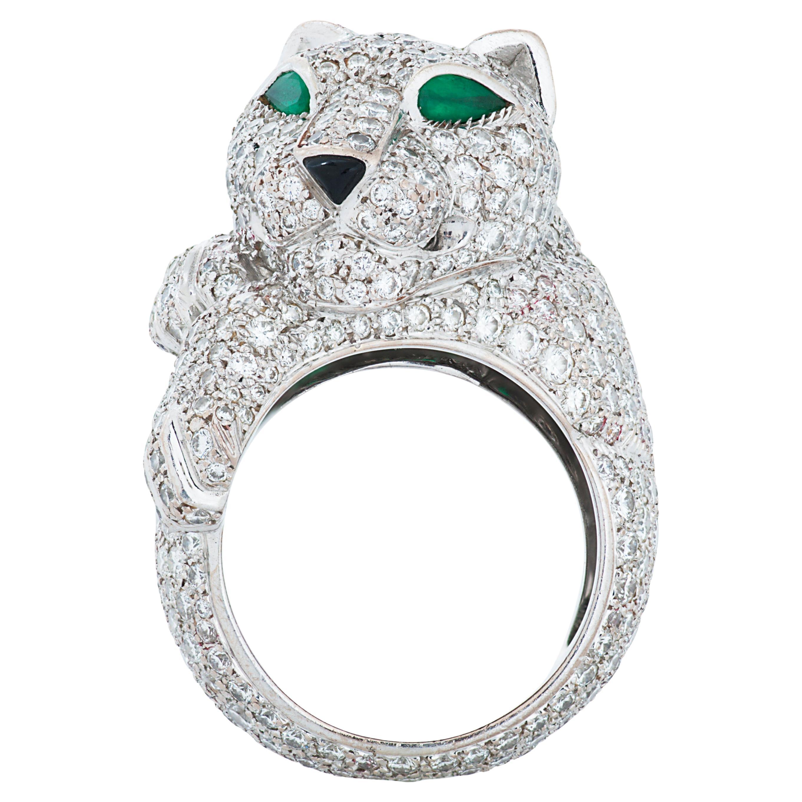 Panthere De Cartier diamond panther head ring in 18k white gold, with emerald eyes and an onyx nose.

This Cartier ring features approximately 6.00 carats of round brilliant cut diamonds pave set over the panther as well as around the shank. 

The