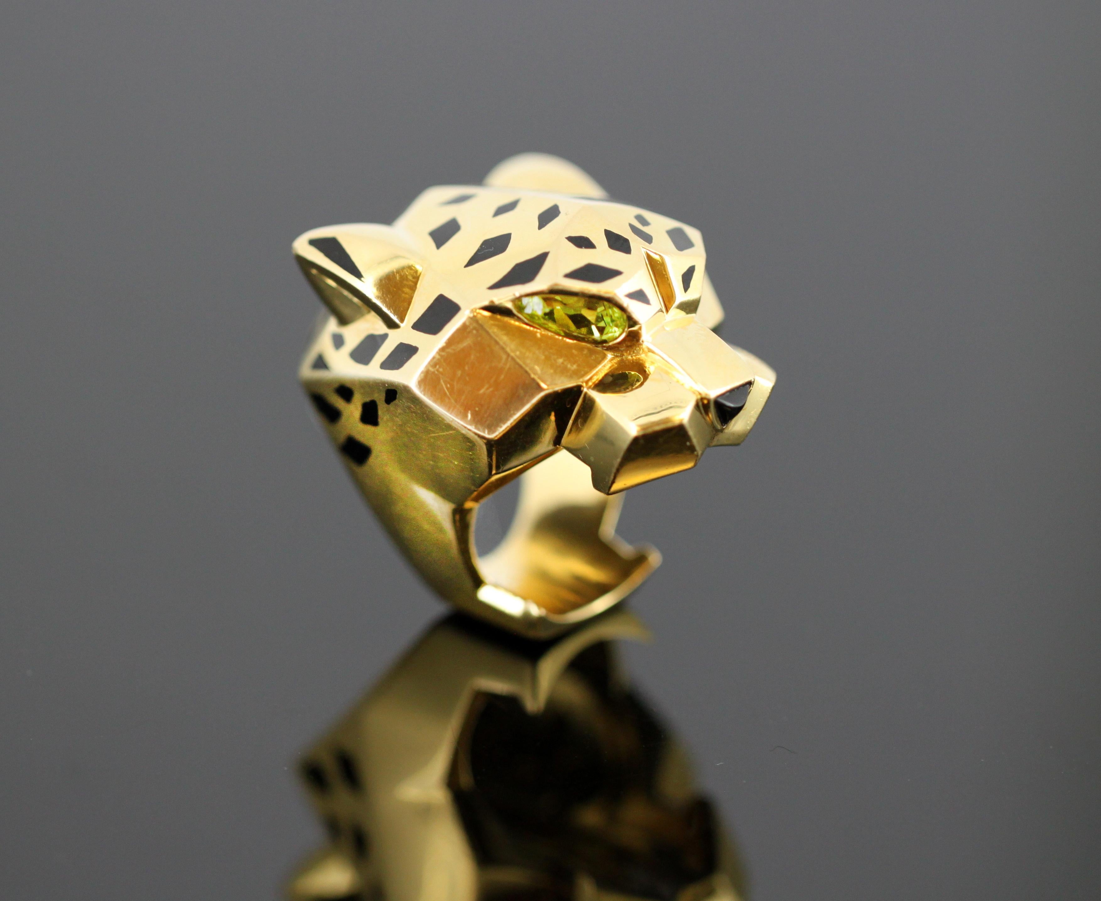 PANTHÈRE DE CARTIER RING - YELLOW GOLD, LACQUER, PERIDOTS, ONYX.
Designer: Cartier
Serial: 15347B
Made in France Circa 1990's
Fully hallmarked.

The Cartier panther first leapt into the Maison's aesthetic in 1914. Whilst Louis Cartier was the first