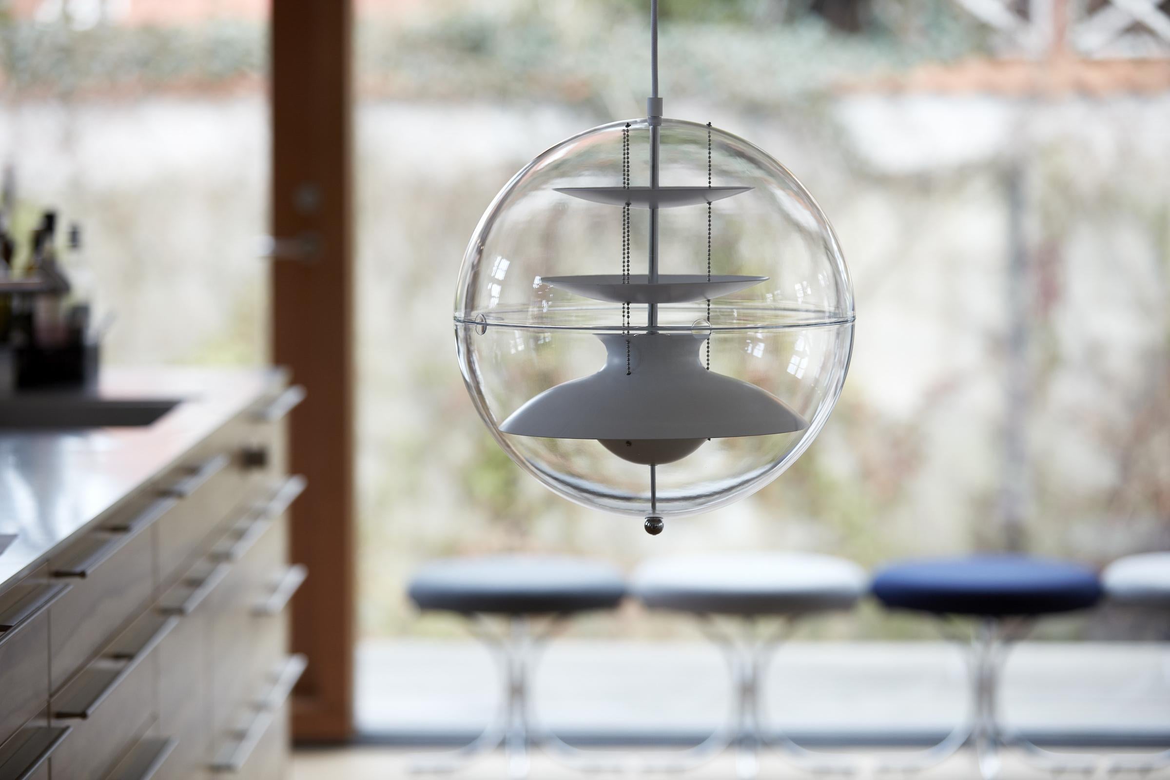 Pendant with a transparent acrylic sphere. White reflectors inside, suspended by three steel chains. Incl. ceiling canopy.    Material:   White lacquered aluminum reflectors   Ceiling canopy is made of metal (white lacquered)    Light source:   E12