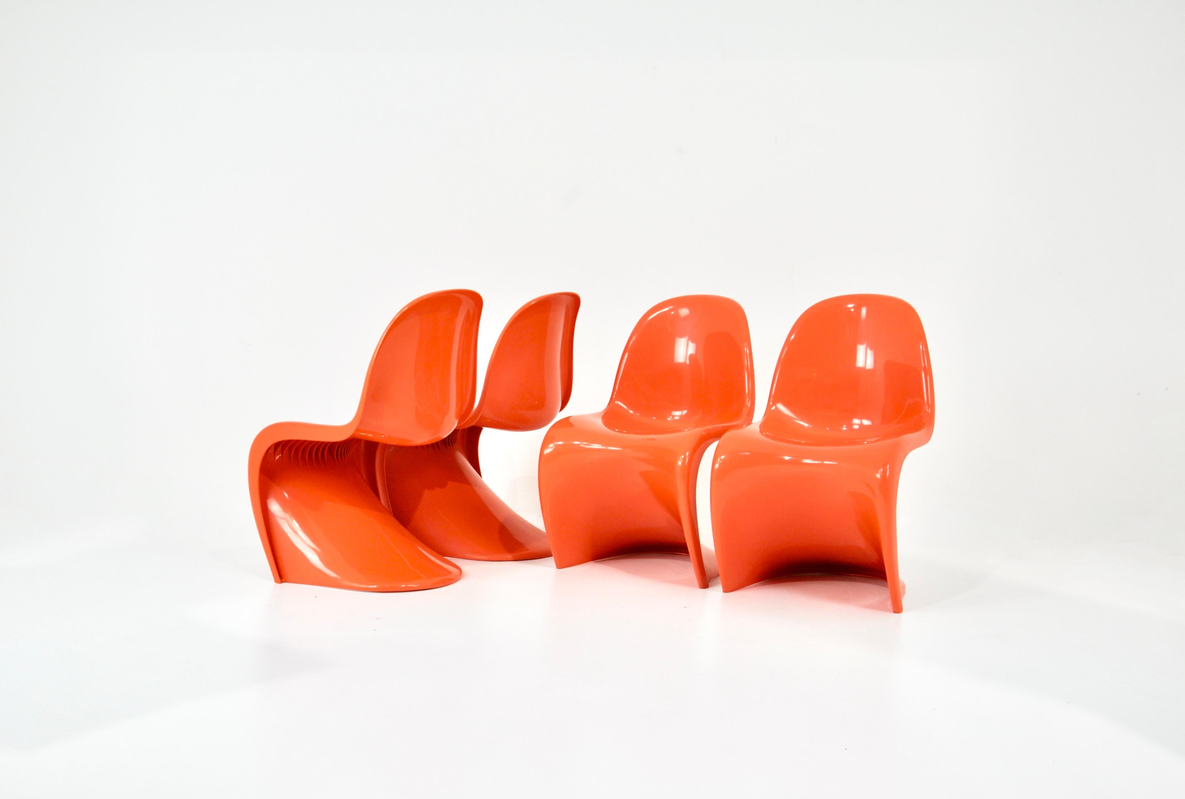 Set of 4 orange fiberglass chairs designed by Verner Panton. stamped under seat.  Wear due to time and age.