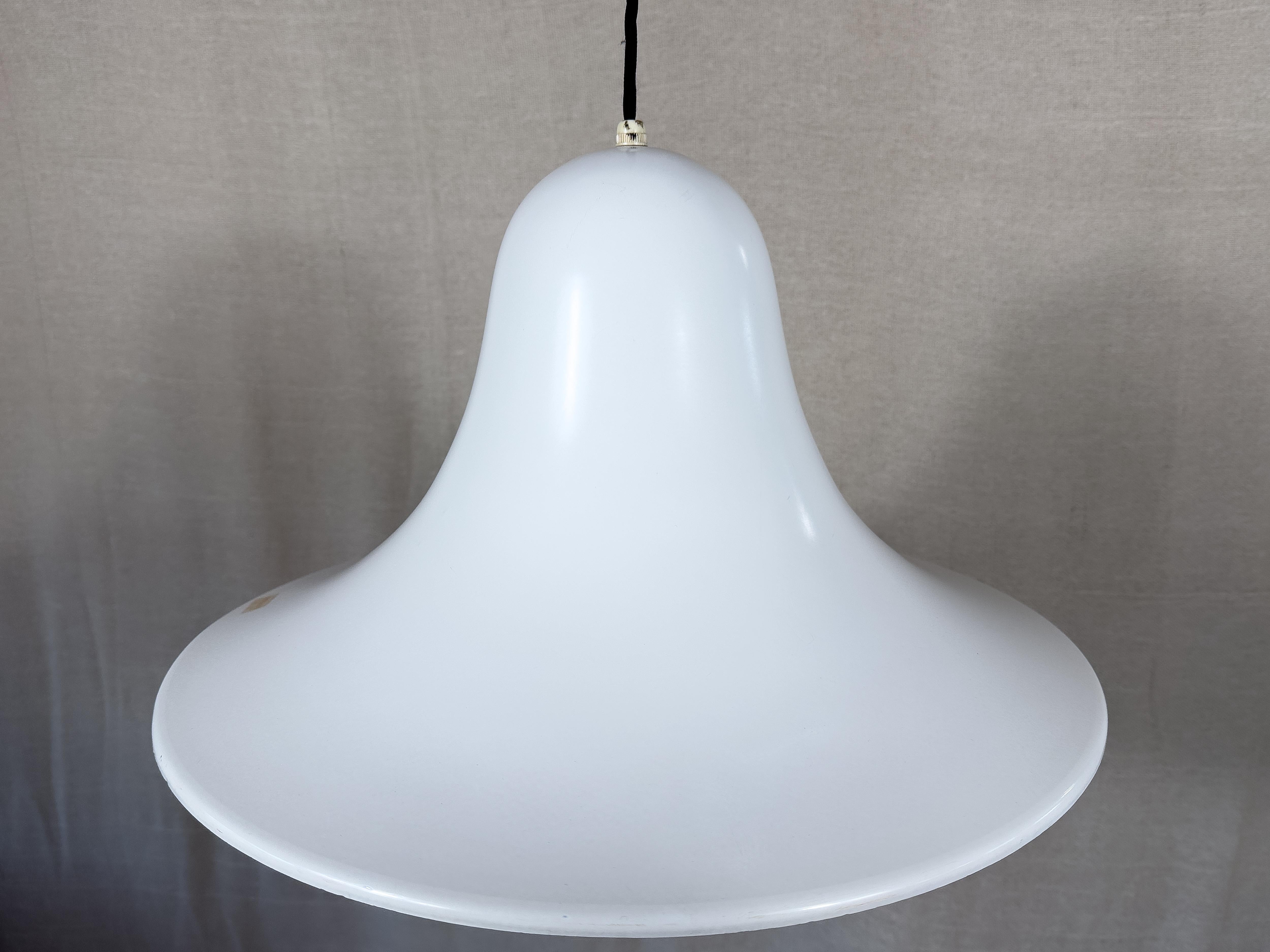 Disegnata da Verner Panton per Louis Poulsen negli anni '70, questa lampada a sospensione dalla forma molto elegante è realizzata in alluminio laccato bianco. Le curve morbide del pezzo sono emulate nella delicata tonalità di luce prodotta da questo