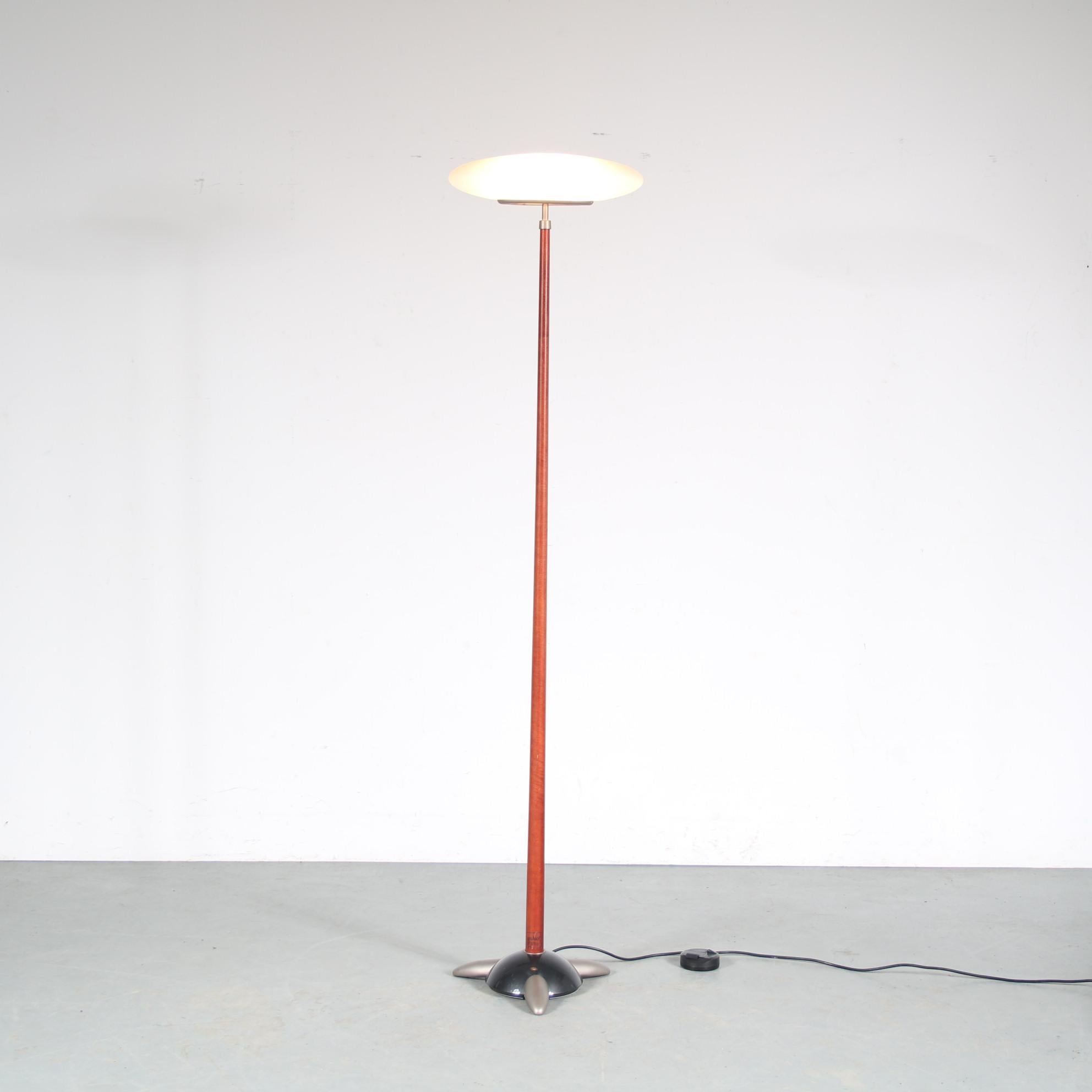 

A beautiful elegant floor lamp, designed by Matteo Thun and manufactured by Flos in Italy around 1990.

This is a rare first edition of this iconic piece! It has a warm brown wooden arm on a three legged base, holding a glass shade at top. This