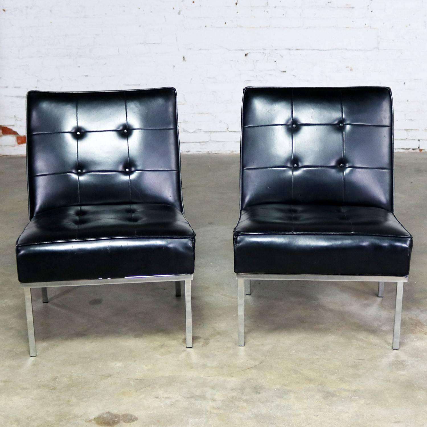 Awesome pair of Mid-Century Modern or MCM slipper chairs in black faux leather or Naugahyde by Paoli Chair Co. done in the style of Florence Knoll. Original tag on one chair dated 1968. They are in good original condition. There are a few repaired