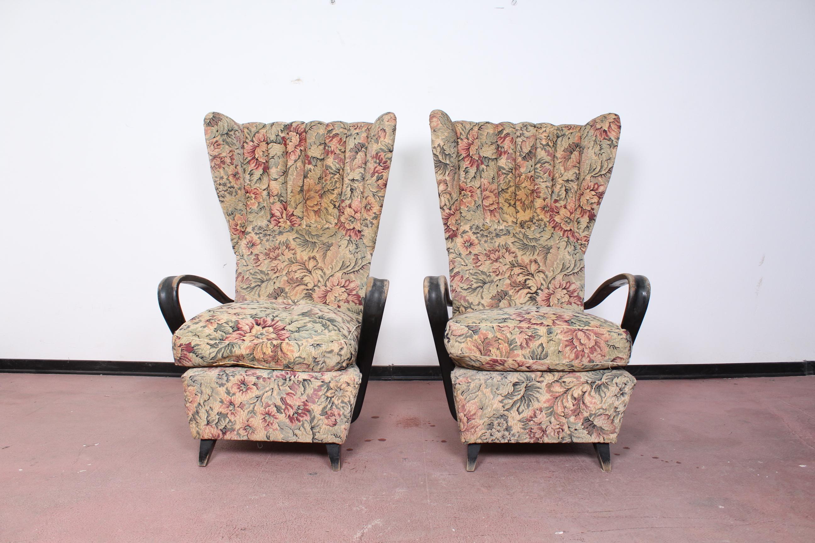 Pair of Paolo Buffa armchairs, Italy, circa 1950. Stylish wingback armchairs with carved wooden arms, in floral original fabric.
 Wear consistent with age and use.