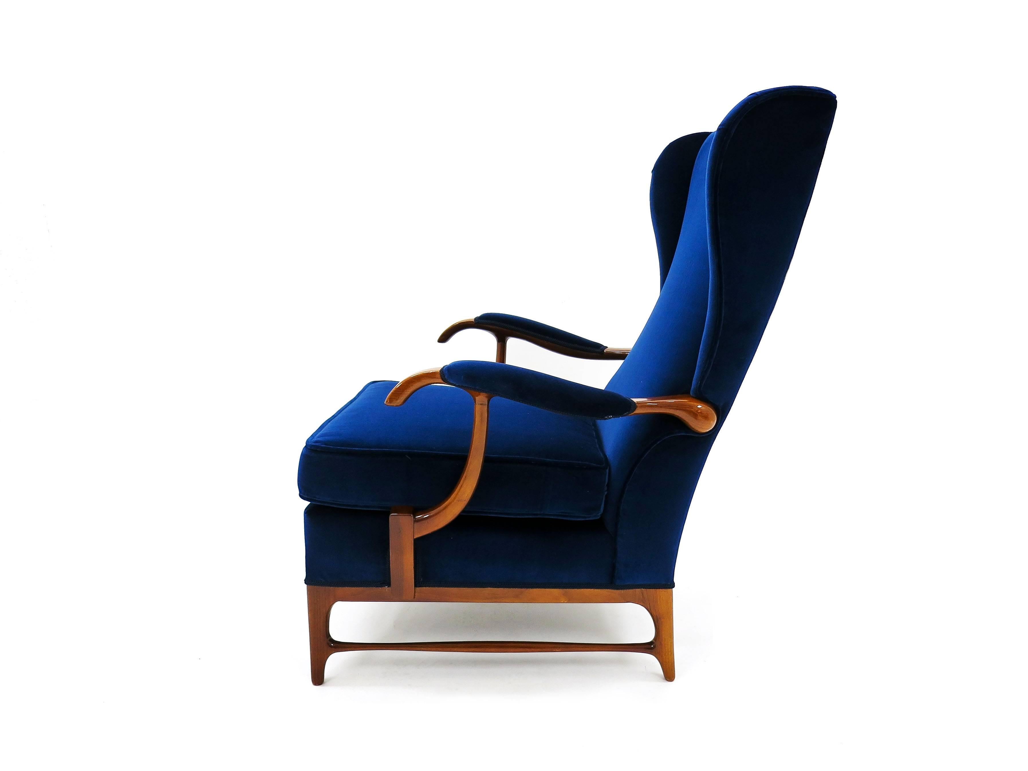 A Mid-Century wingback armchair of small proportions designed by Paolo Buffa in the 1950s. Walnut frame reupholstered with a royal blue velvet and backed with a 1950s inspired geometric design fabric, all in an excellent original condition.

A