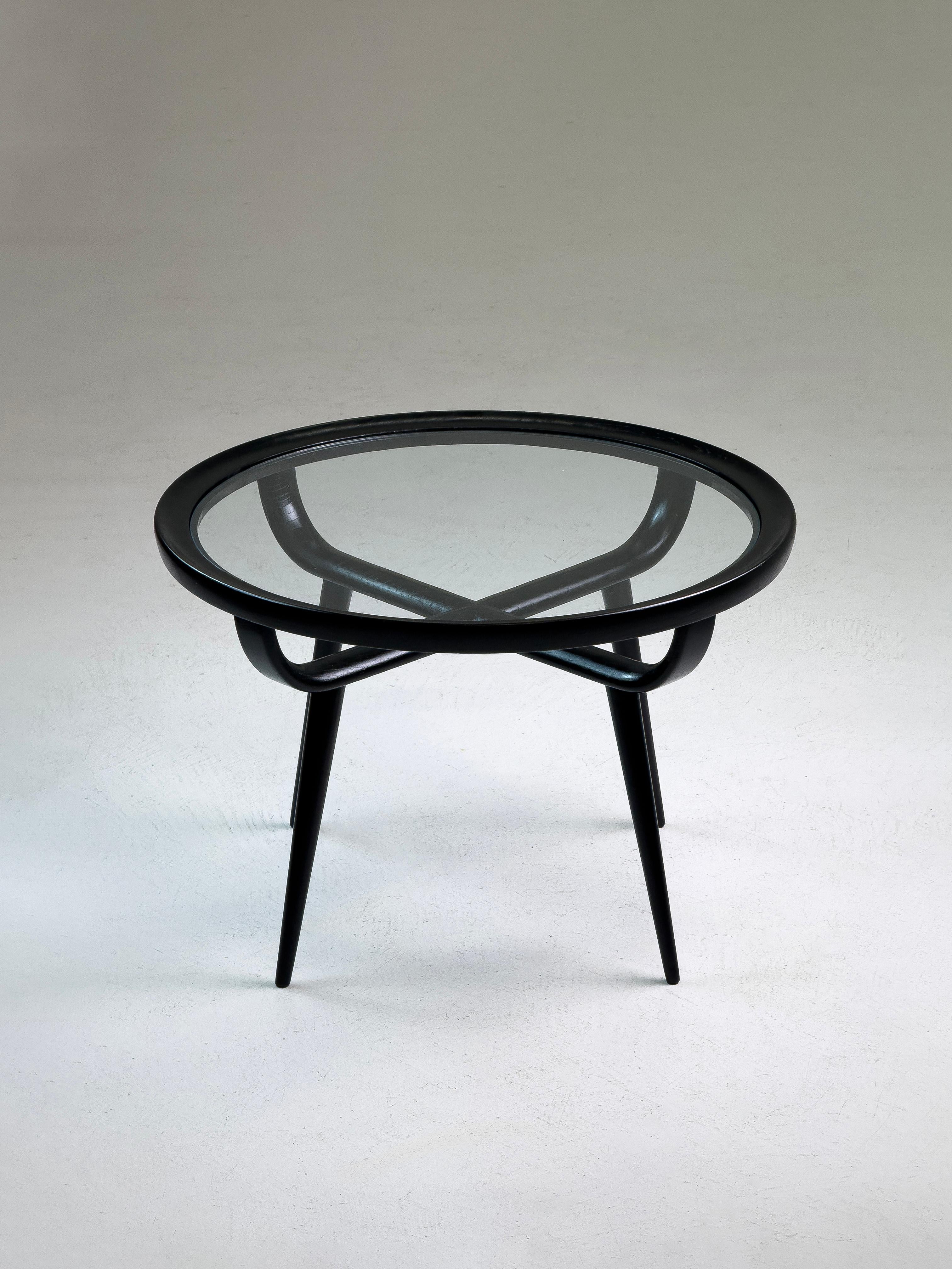 
Paolo Buffa (attribué) - Table basse ronde en noyer noir et verre, Italie, années 1950-60

Cette table basse ronde raffinée, attribuée au célèbre designer italien Paolo Buffa, a été fabriquée en Italie dans les années 1950 ou au début des années