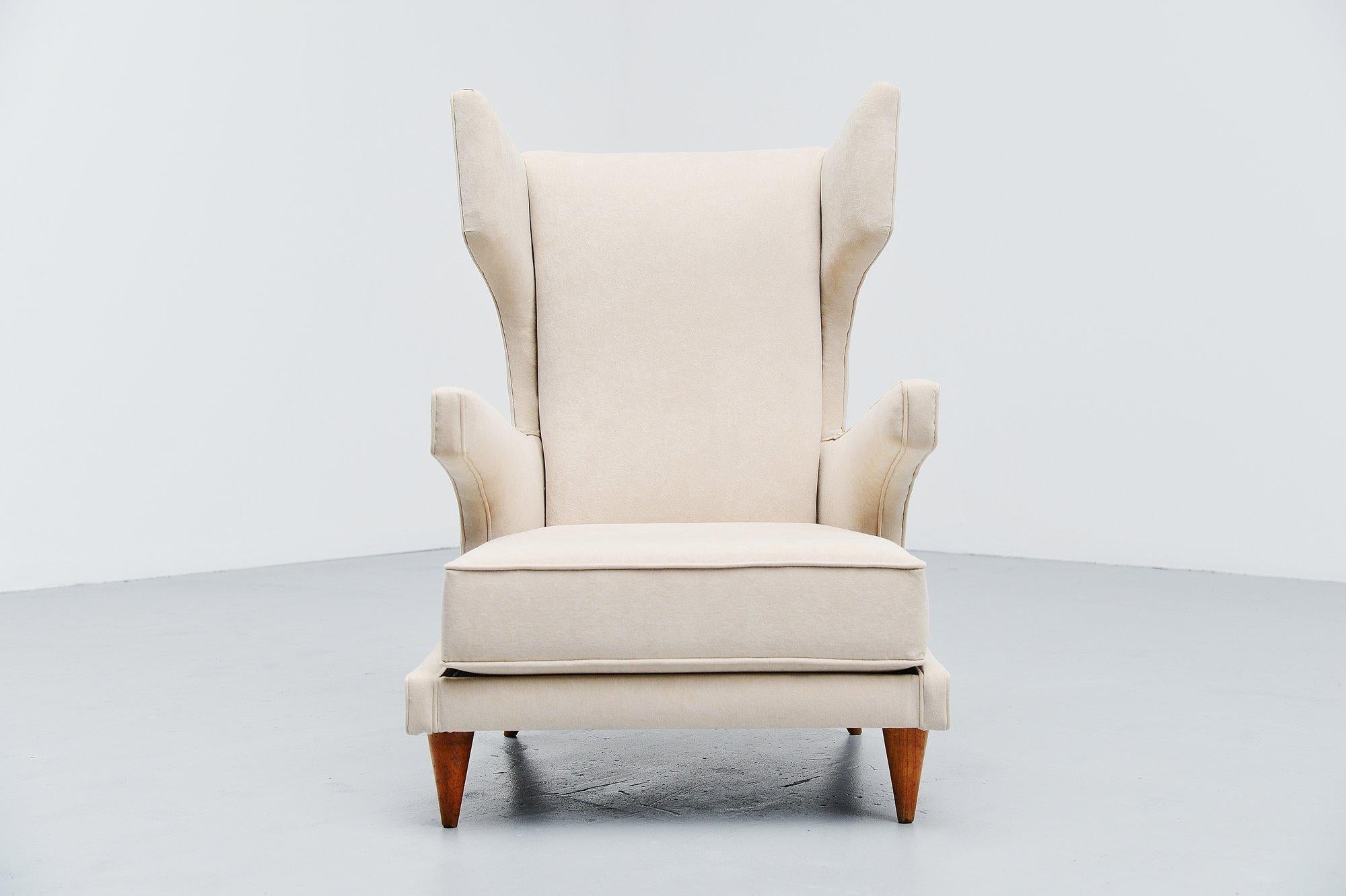 Very nice sculptural wingback low lounge chair attributed to Paolo Buffa, Italy 1950. This chair has an amazing shape, wingback design. Low lounge chair with beech wooden feet and newly upholstered with cream velvet upholstery. Sophisticated design,