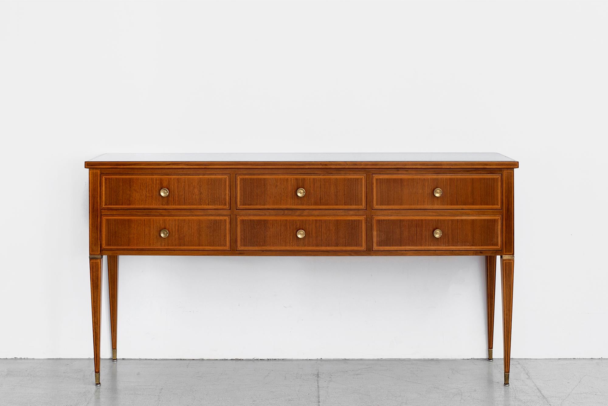 Gorgeous sideboard attributed to Paolo Buffa.
Mahogany wood with black glass top - intricately inlaid wood trim detailing 
Elegant tapered legs, six drawers for storage and ornate brass hardware.
 