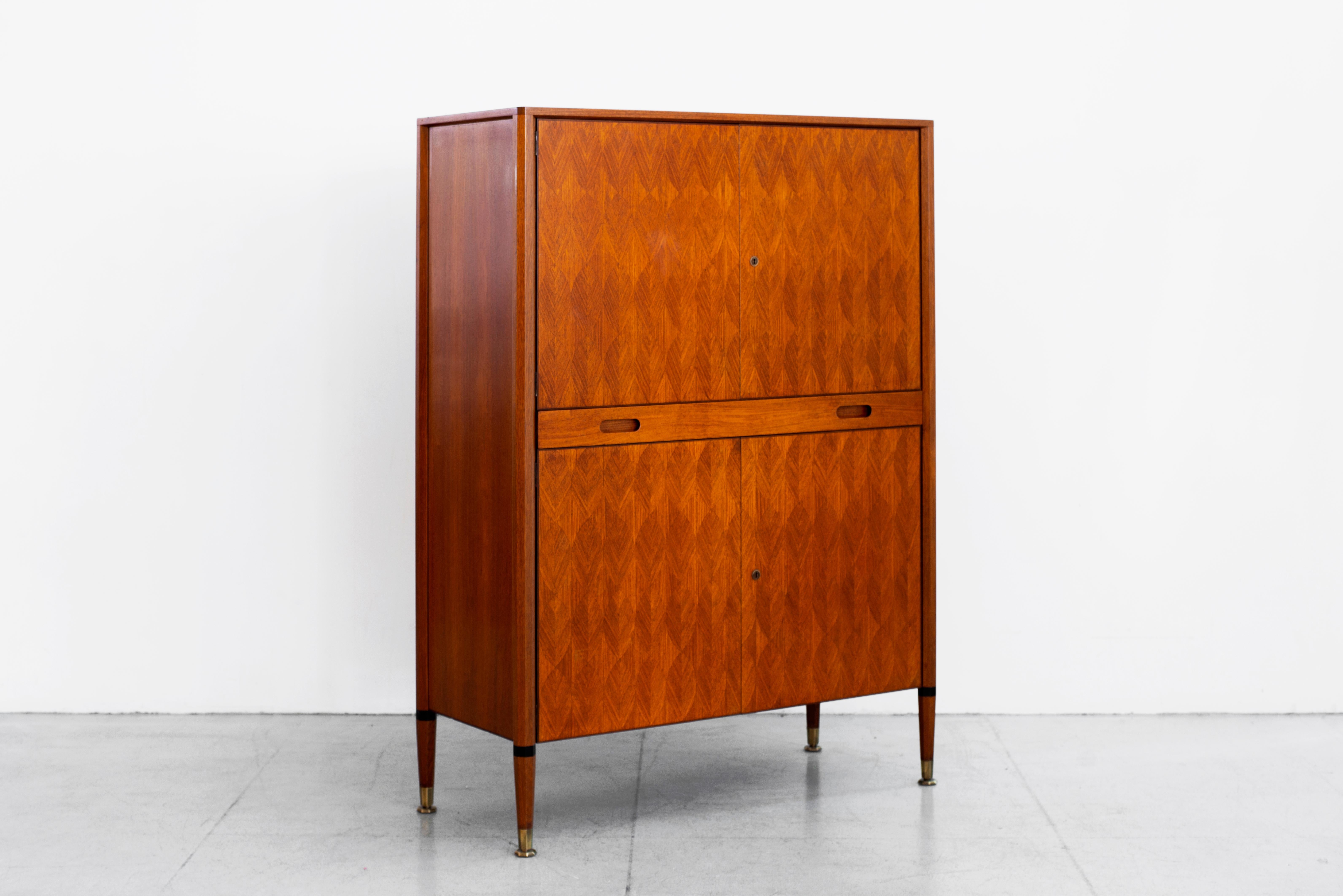 Gorgeous cabinet by Paolo Buffa, circa 1940s
Wonderful craftsmanship in patterned rosewood - Four doors and one pull out drawer that doubles as a surface with a sliding mechanism. 
Tapered legs with inlay 
Brass feet with original key.