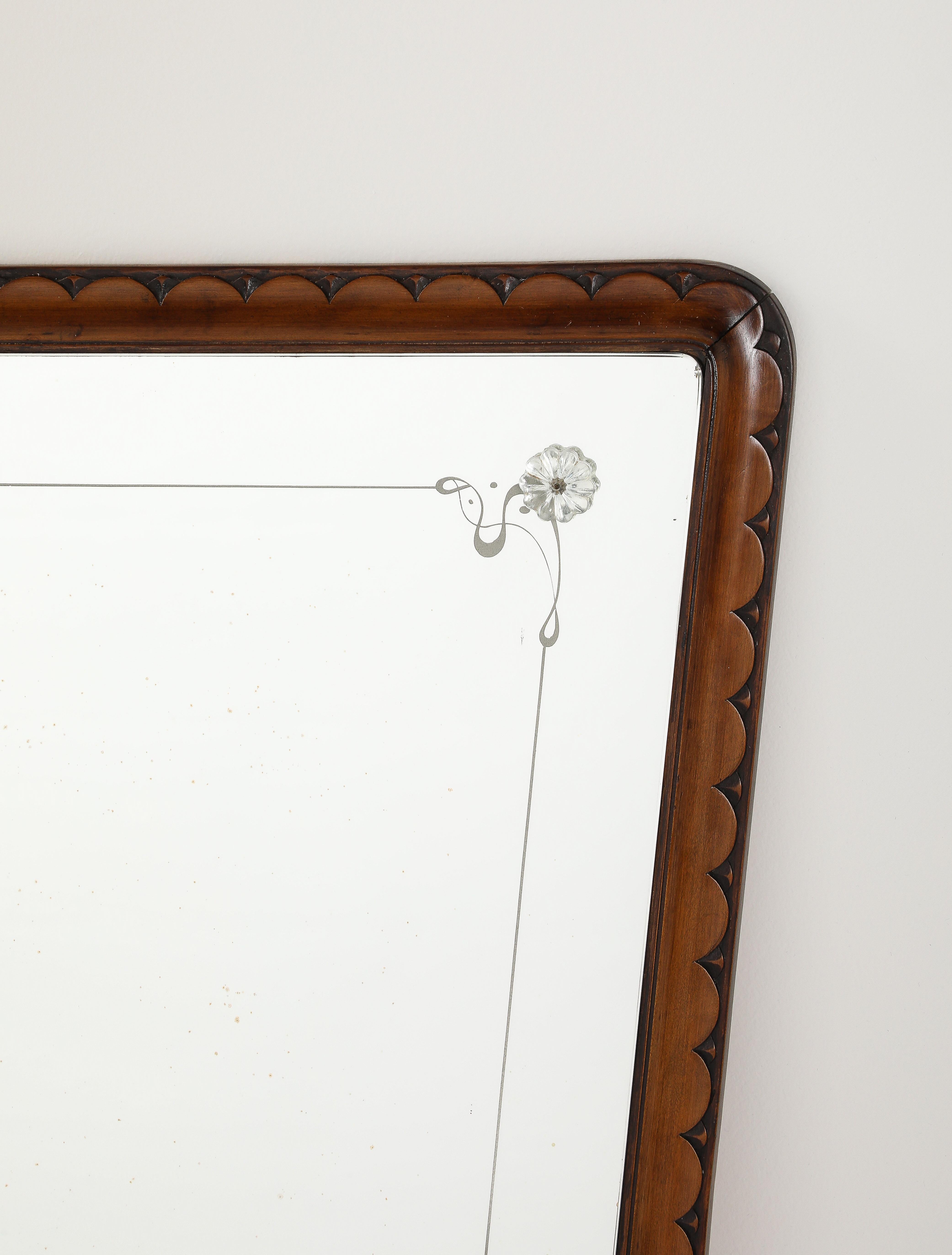 Espejo de nogal finamente tallado diseñado por Paolo Buffa, Italia, hacia 1940. Este exquisito y grandioso espejo de pared tiene forma trapezoidal, con un excepcional y delicado marco de nogal tallado a mano con motivo de festón, la placa del espejo