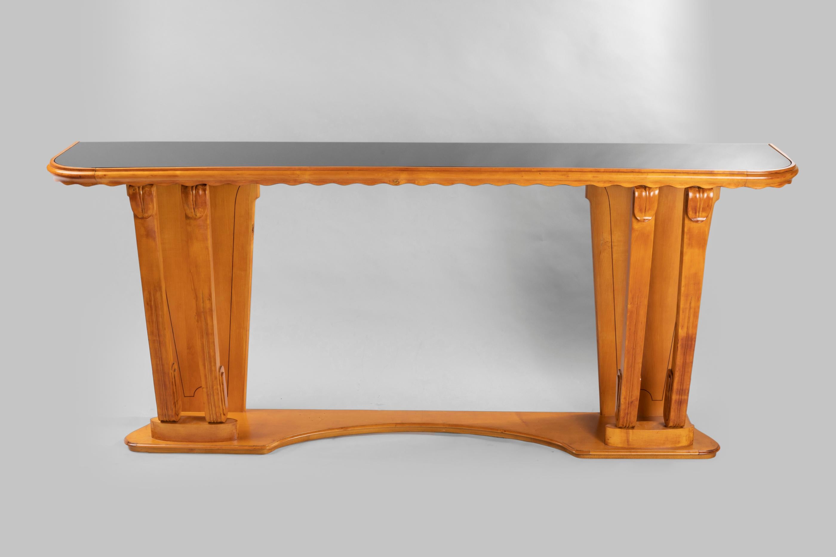 Graciousness for this ash tree console 1940 with a black glass on top. Paolo Buffa, renowned Italian designer for his midcentury furniture: Tradition, modernity in his easy
living -in pieces.