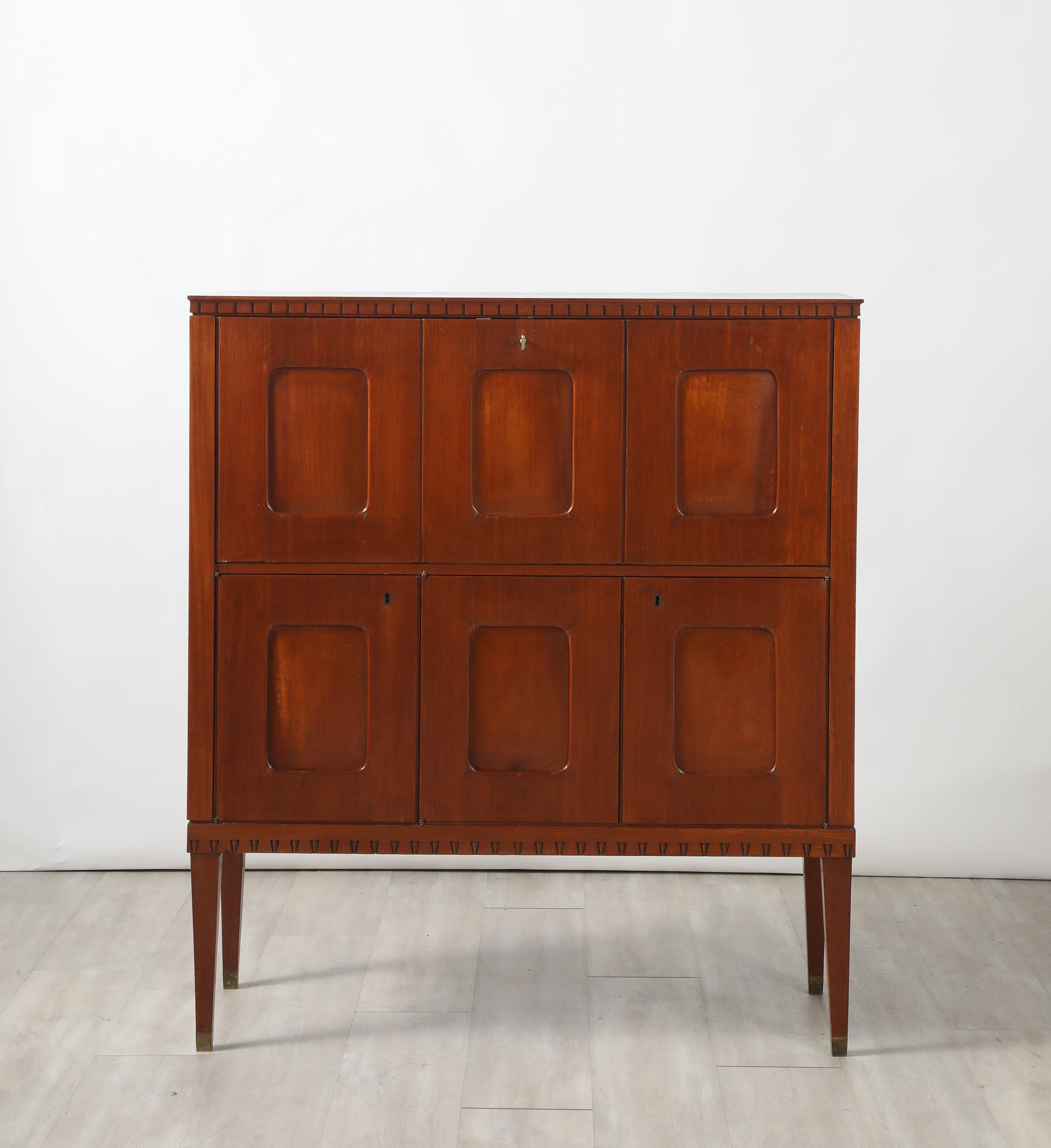 Excepcional y raro mueble de caoba Paolo Buffa, Italia, circa 1950, con panel frontal moldeado, parte superior rectangular y molduras dentil talladas. (Un par disponible; el otro es un escritorio desplegable o una secretaria). 
El armario de la