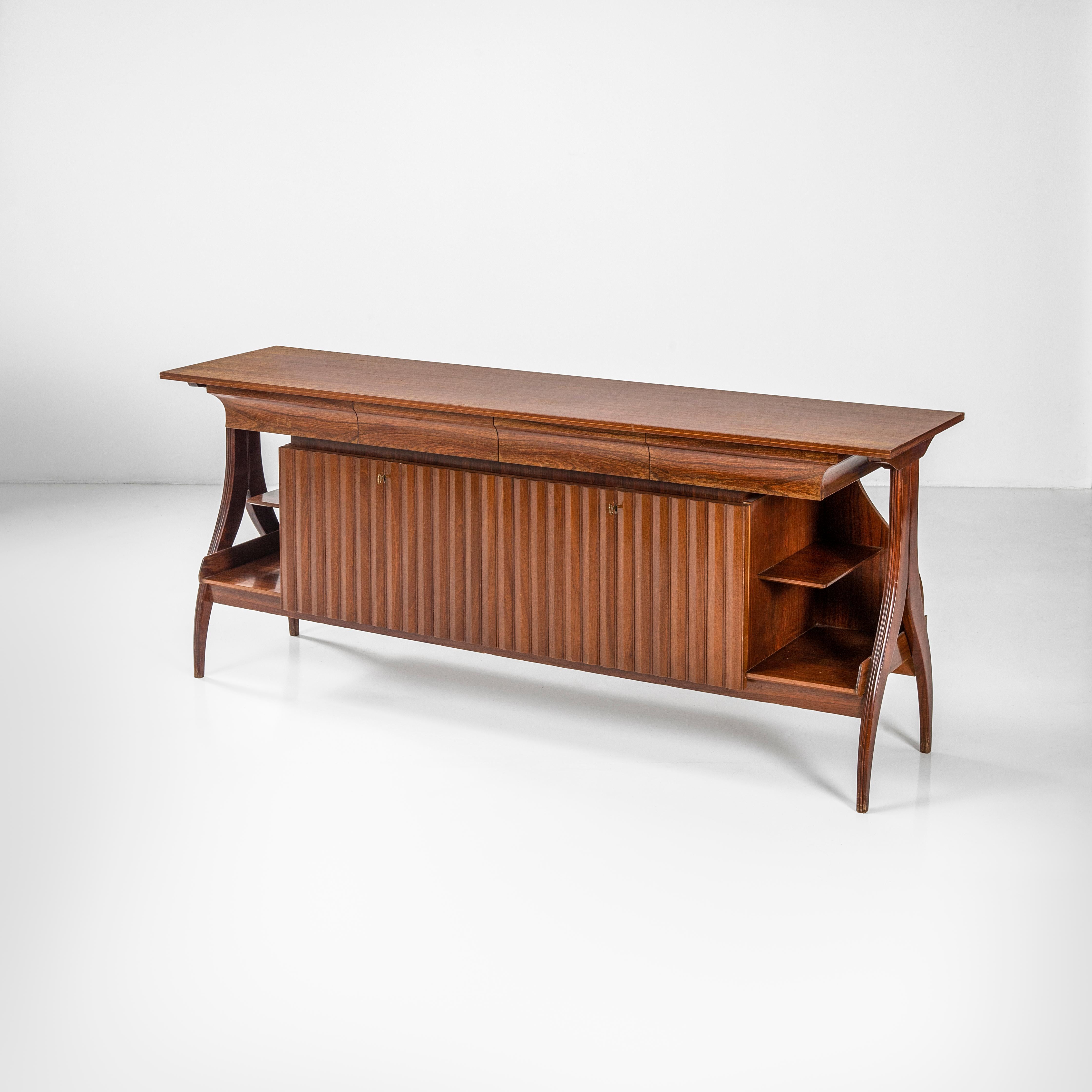 Elegant and discreet sideboard that combines some of the typical design elements of Paolo Buffa, a great protagonist of the design of the first half of the 20th century: thus, one notices the double leg in carved and curved wood, with upper rib.
