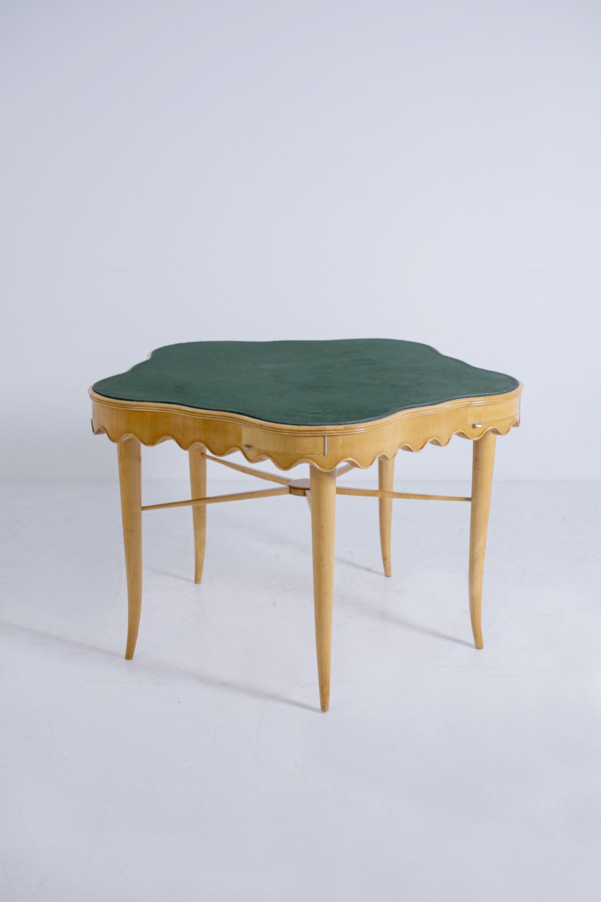 Elegant game table by Paolo Buffa of the 1950s. Excellent quality and restored.
The table is flower shaped with beautiful curves. Made of maple wood, the table has under the top a wave skirt that runs around the entire perimeter of the table. Above