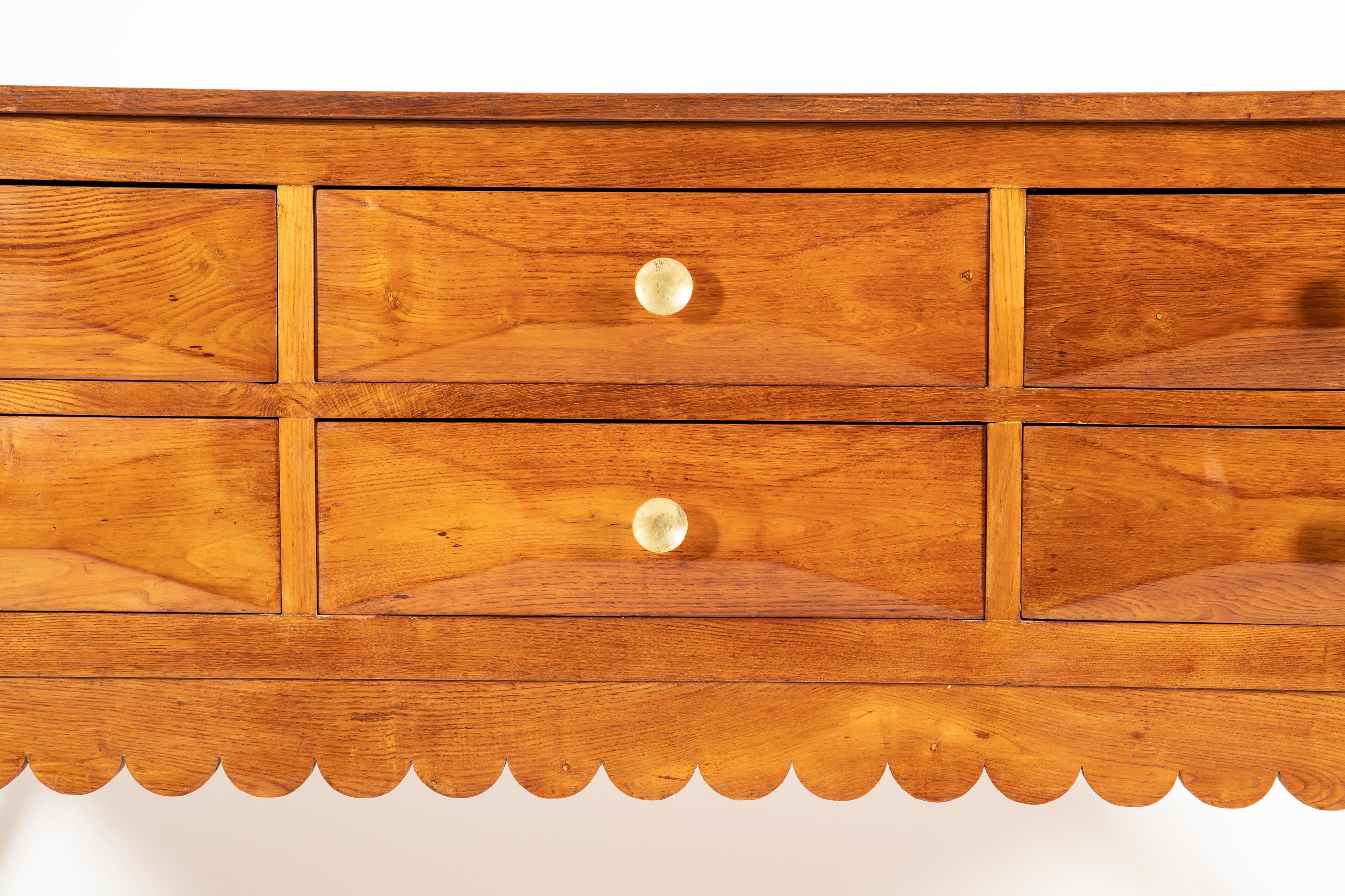 Extraordinary and rare solid oak credenza with scalloped edge details, featuring six rusticated ashlar-work drawers, for tapered legs ending in brass sabots and beautiful and original brass handlers. This credenza has been designed by Paolo Buffa in