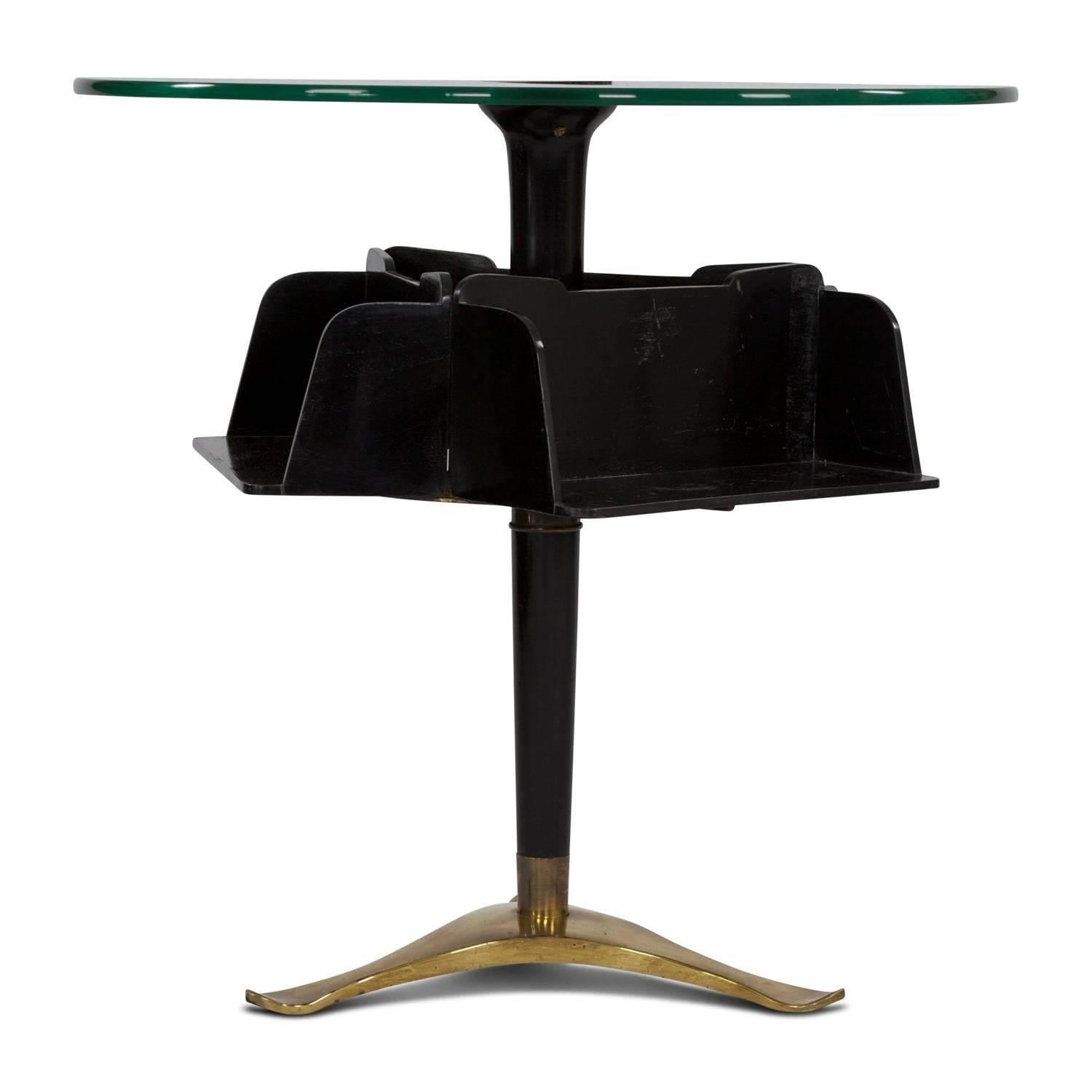 This side table was designed by Paolo Buffa in Italy in the 1940s. It has three shelves attached below the tabletop for book storage. This design element gives the table an extravagant appearance. The centre leg is mounted on a brass base. It is in
