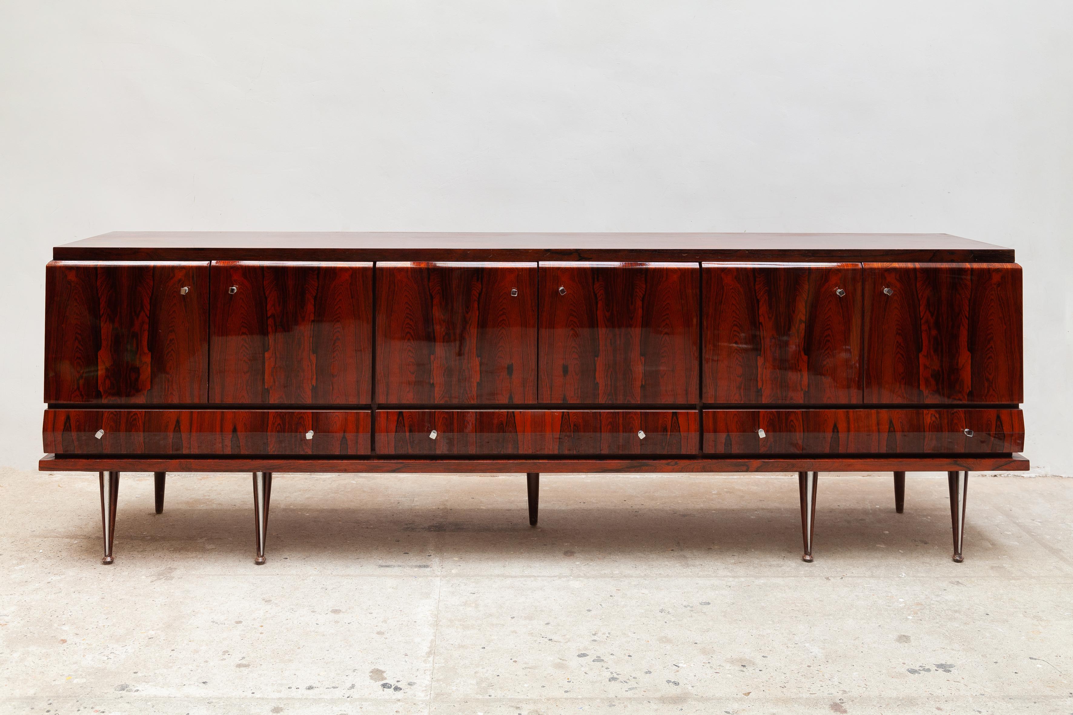 Mid-Century Modern beautiful large sideboard characterizes the Italian atmosphere by its clear and strict modernist design language. The sideboard has a length of 225 cm in style of Paolo Buffa with functional three doors and open interior