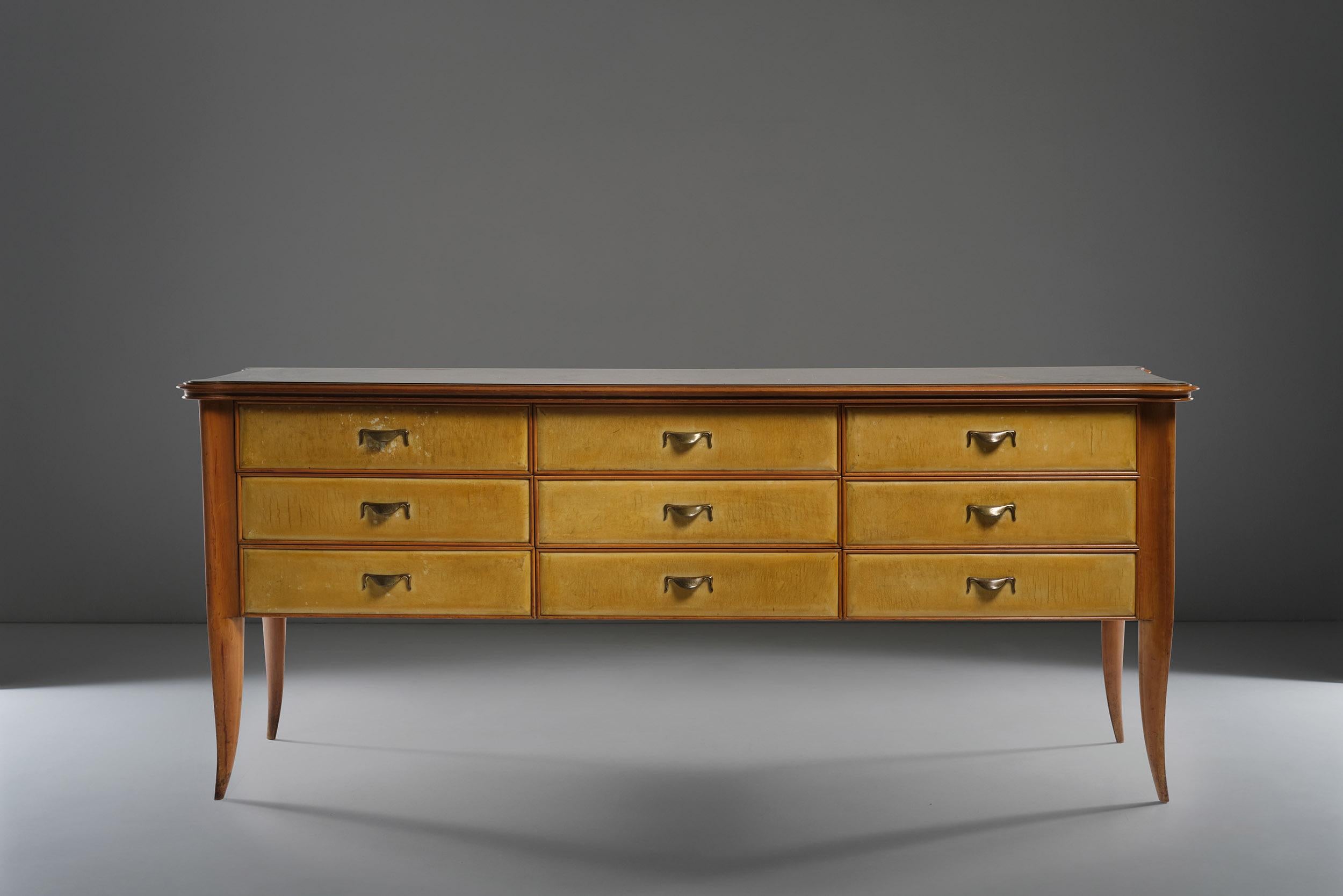 Wonderful Italian sideboard - or chest of drawers - designed by Paolo Buffa in the 1950s. Refined and unmistakably unique piece thanks to its painted glass top, its wooden structure with coated parchment paper and brass handles. The functionality of