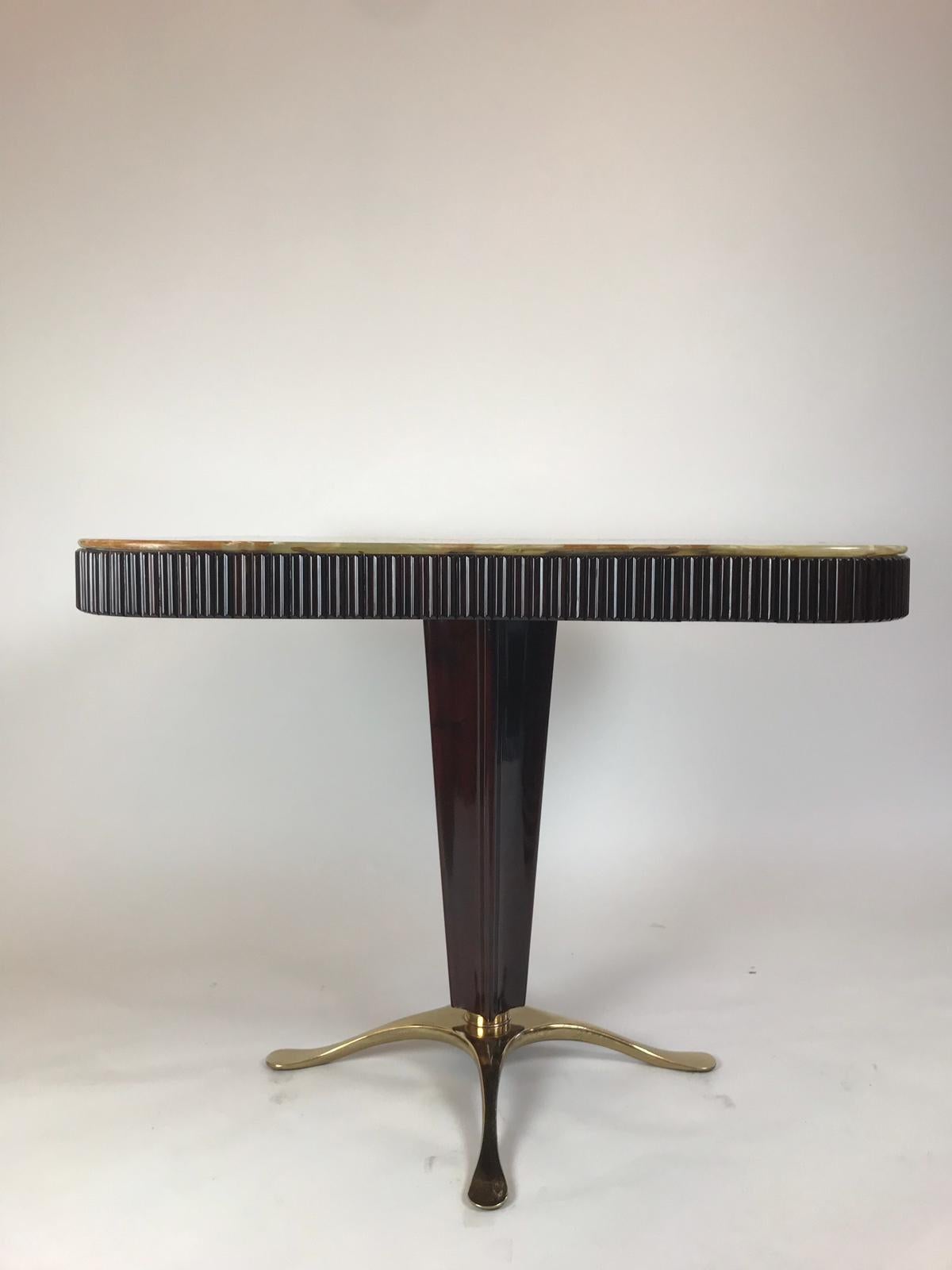 A fabulous occasional/small dining table designed by Paolo Buffa. It is designed in mahogany with a pedestal central leg with brass feet and has elegant fluting around the sides. On top sits the original onyx. It has been fully restored and is a