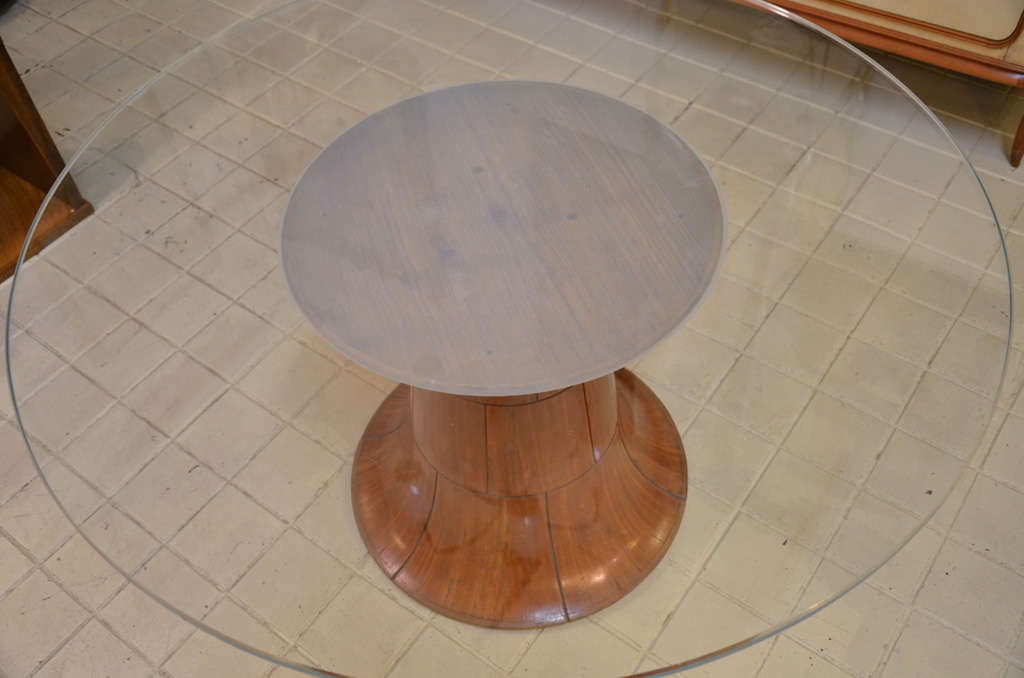 Coffee table with round top in thick ground glass, in the central part sandblasting in the shape of a circle.
The precious exotic wood base extends downwards and is divided into engraved squares that create a decoration.
Italy Mid-Century Modern