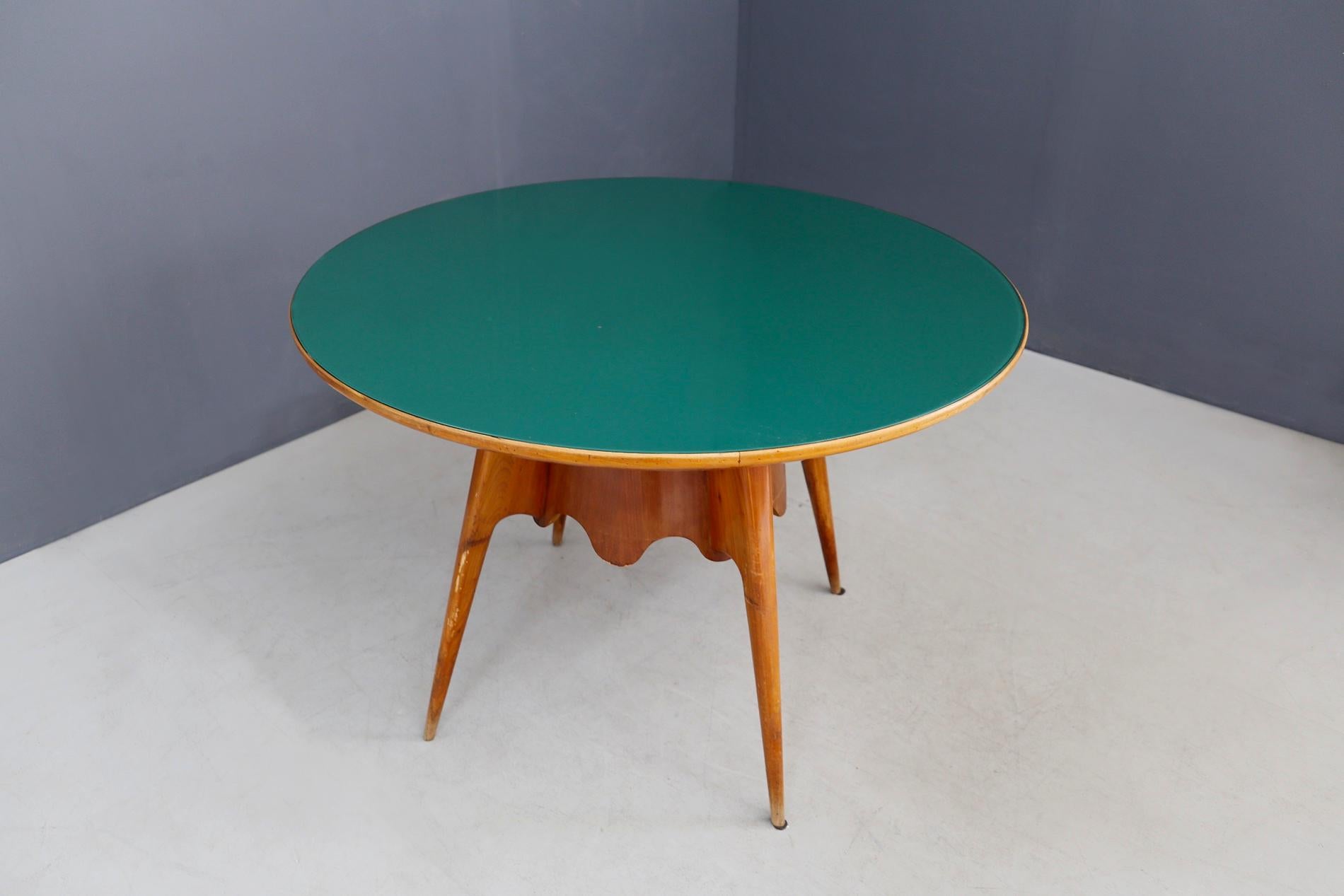 Round dining table designed by Paolo Buffa in 1940. The table has a green glass top in excellent condition.
The structure of the table is made of wood with 4 cone-shaped feet. To enrich its value are its flounces in corrugated wood in the middle of