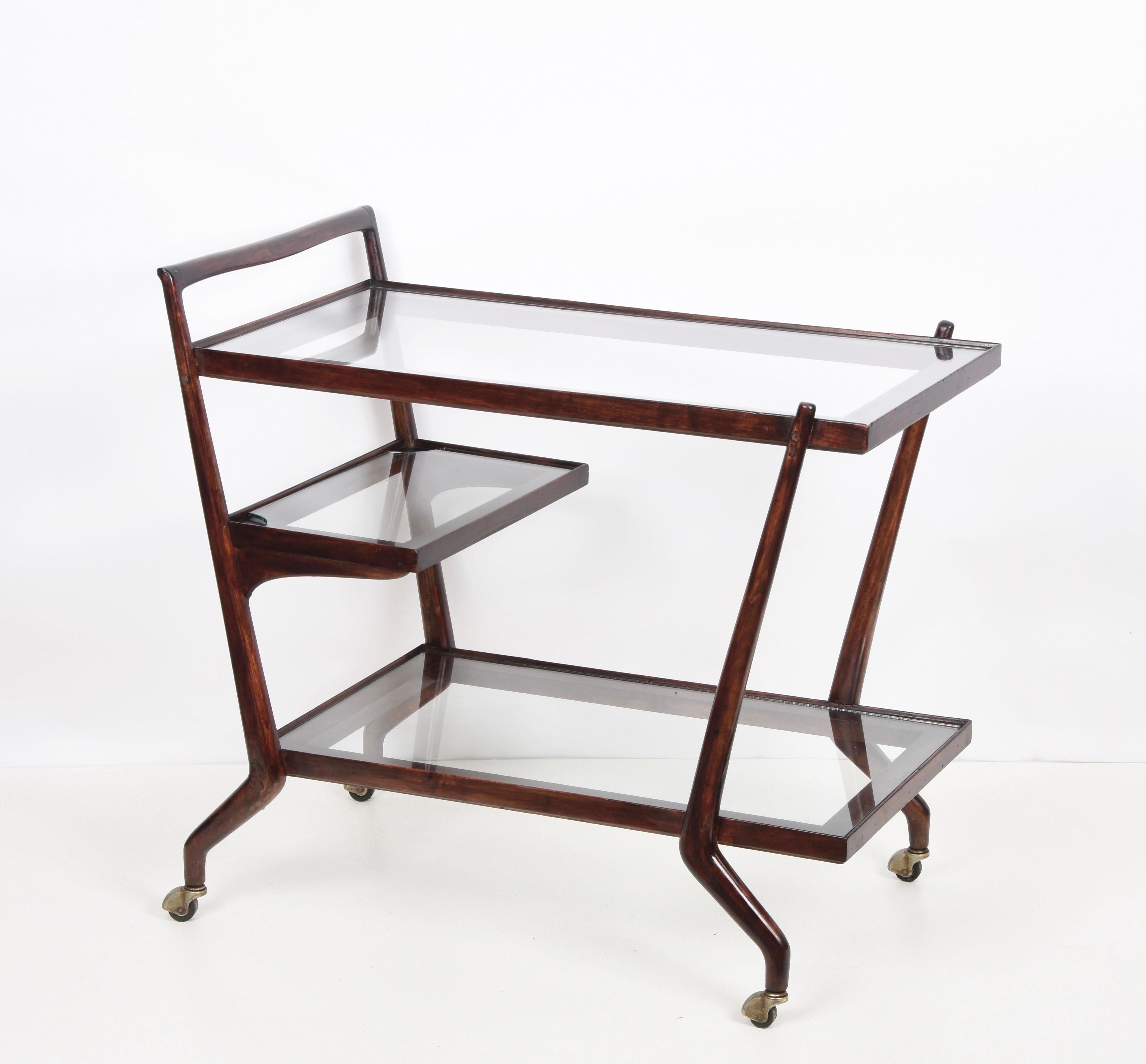 Amazing midcentury three levels mahogany and glass bar cart. This fantastic item was designed by Paolo Buffa in Italy during the 1950s.

This piece presents breathtaking straight lines coinciding with materials, as the mahogany is used for