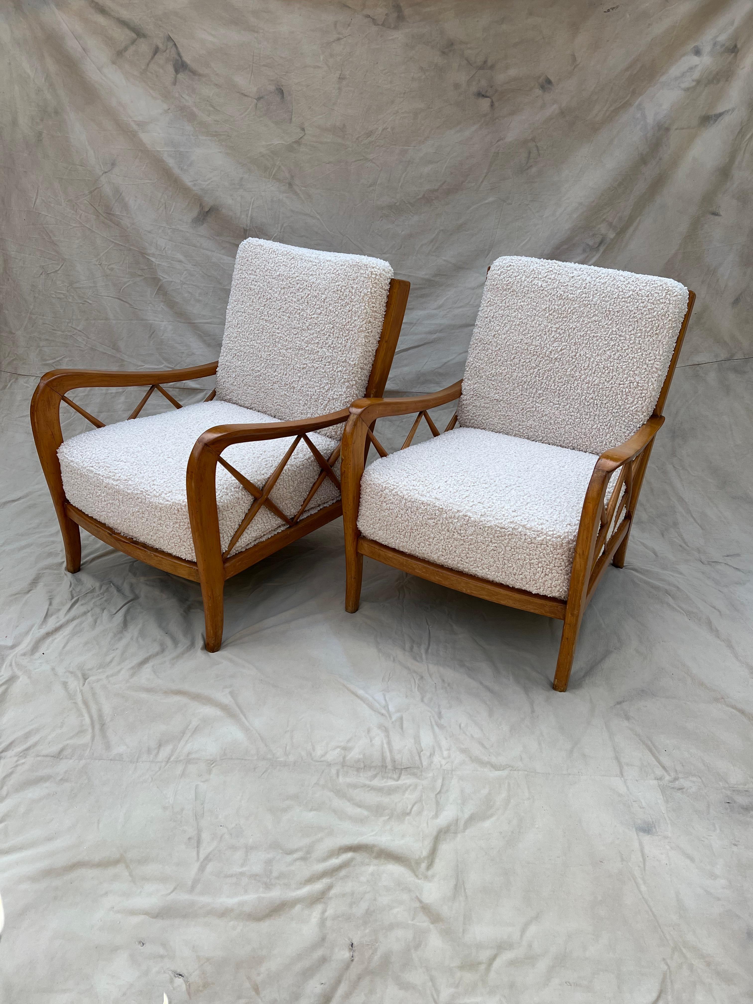 A pair of Italian lounge chairs, by Paolo Buffa and upholstered in Creme Boucle. The pair are exquisitely designed with chic, yet bold detailing - The patinated quality of the wood frame is perfection, the subtle carved wood and the crossed arm