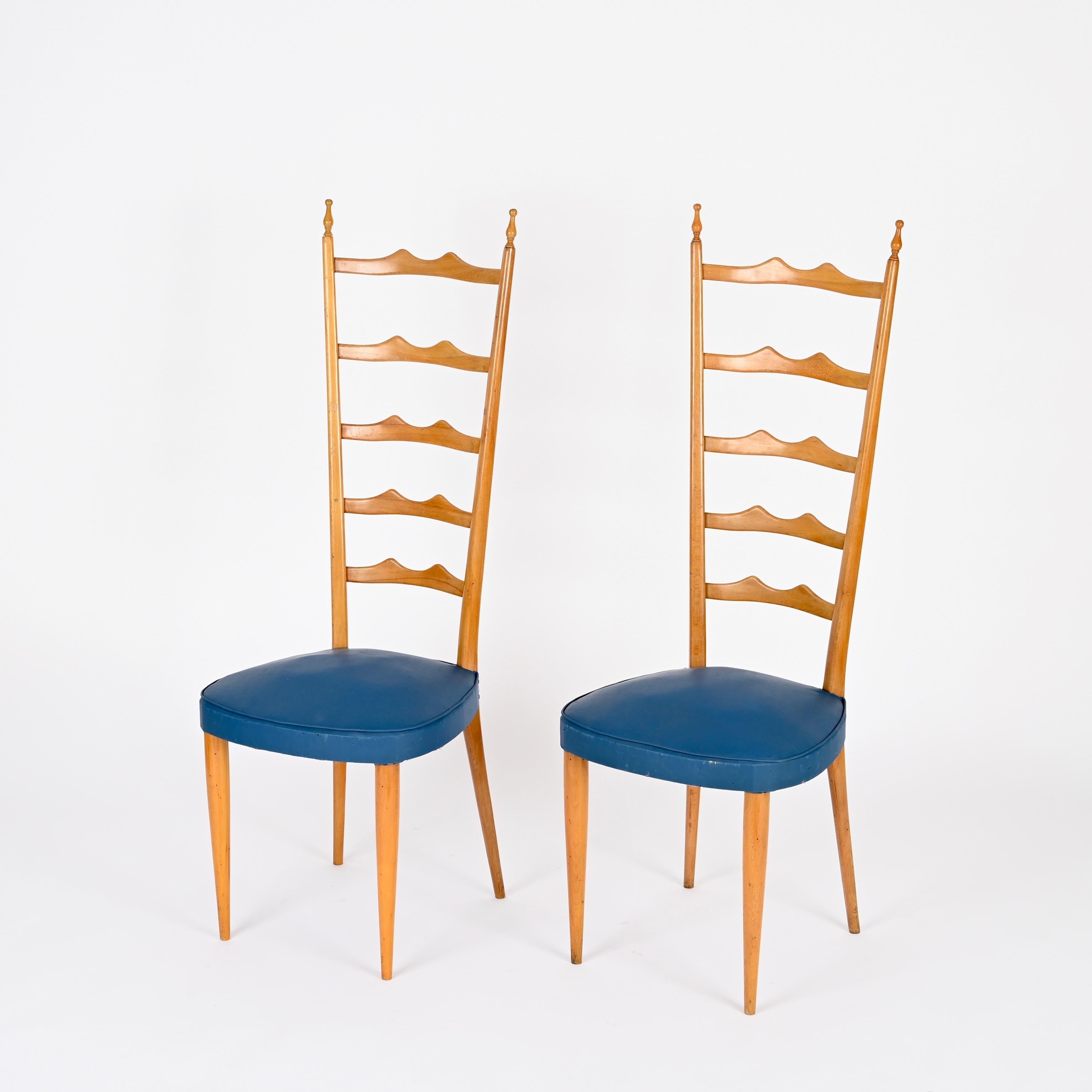 Magnifique paire de chaises Chiavari à haut dossier en bois de hêtre blond avec revêtement en faux cuir bleu. Ces chaises élégantes ont été conçues par Paolo Buffa et produites en Italie dans les années 1950.

Ces chaises finement travaillées