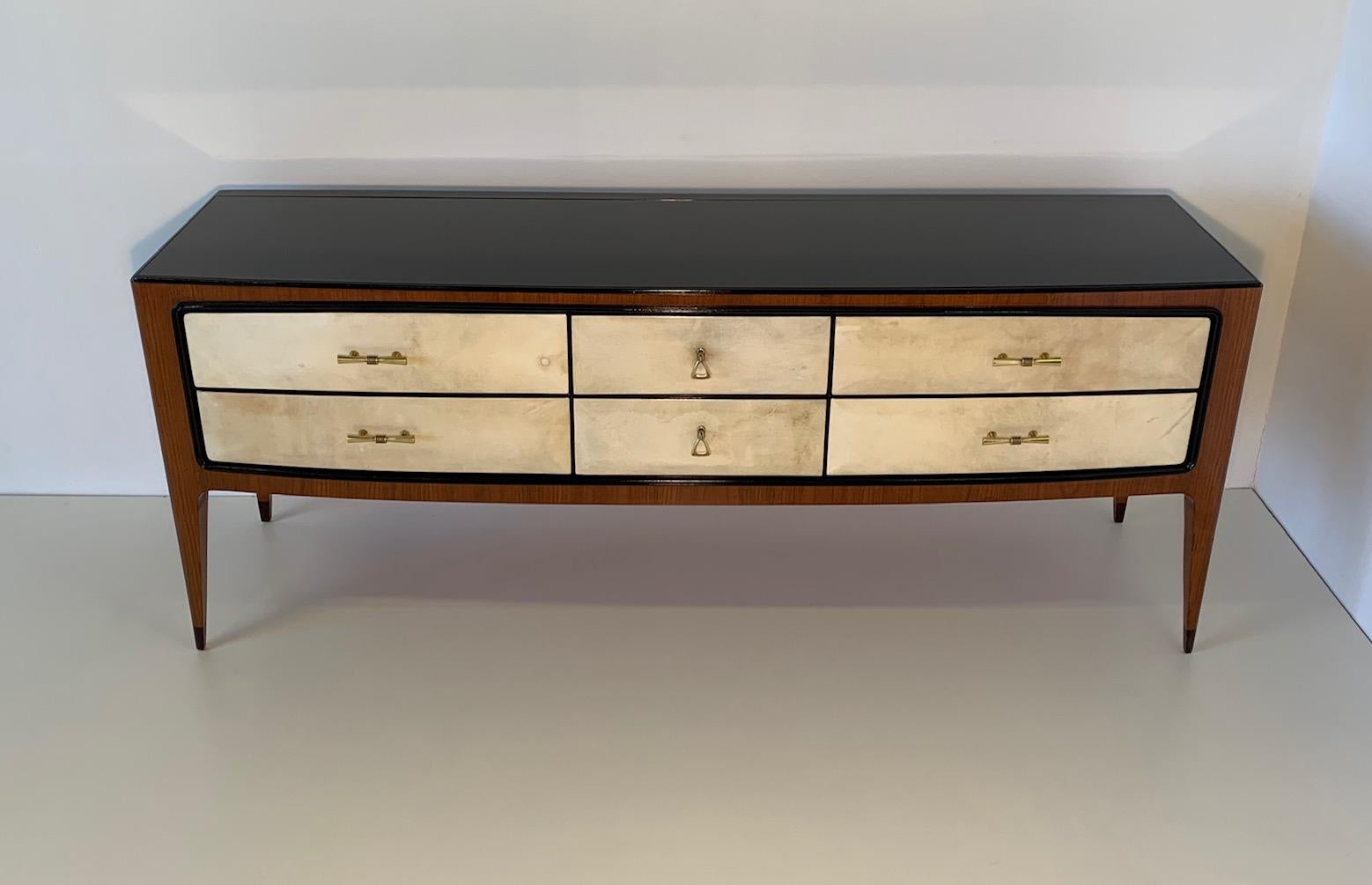 This dresser from the 1950s was made in Italy in walnut with fronts of the drawers in fine parchment leather.
Ebonized wood profiles and black glass top.
Brass handles and keys.
Completely restored.